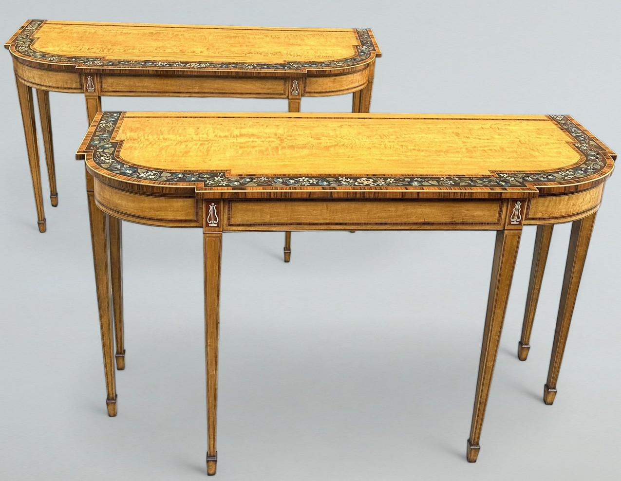 An absolutely stunning Pair of George III Style Polychrome-decorated polished Satinwood Console Tables. In the manner of Seddon, Sons and Shackleton. Circa first quarter of the Twentieth Century, of English origin.  
Each breakfront D-shaped top