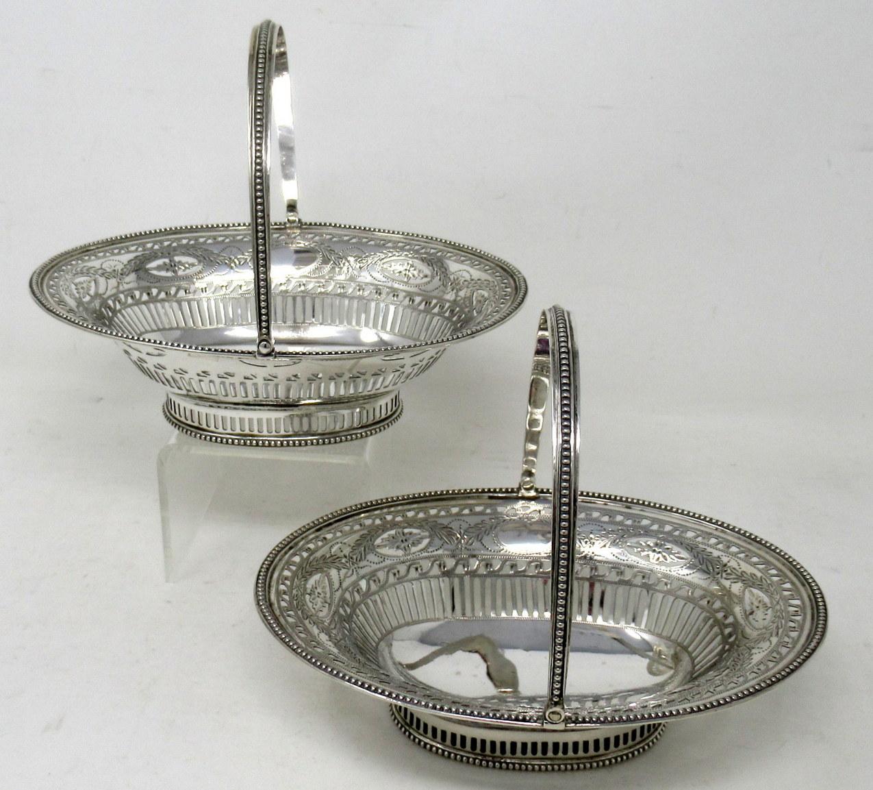 A Superb Example of a Pair of English Sterling Silver Georgian Embossed Bon Bon Dishes, complete with their beaded decorative swing handles. 

Each beaded swing handle and rim above an oval body with lavish pierced and bright cut decoration, ending