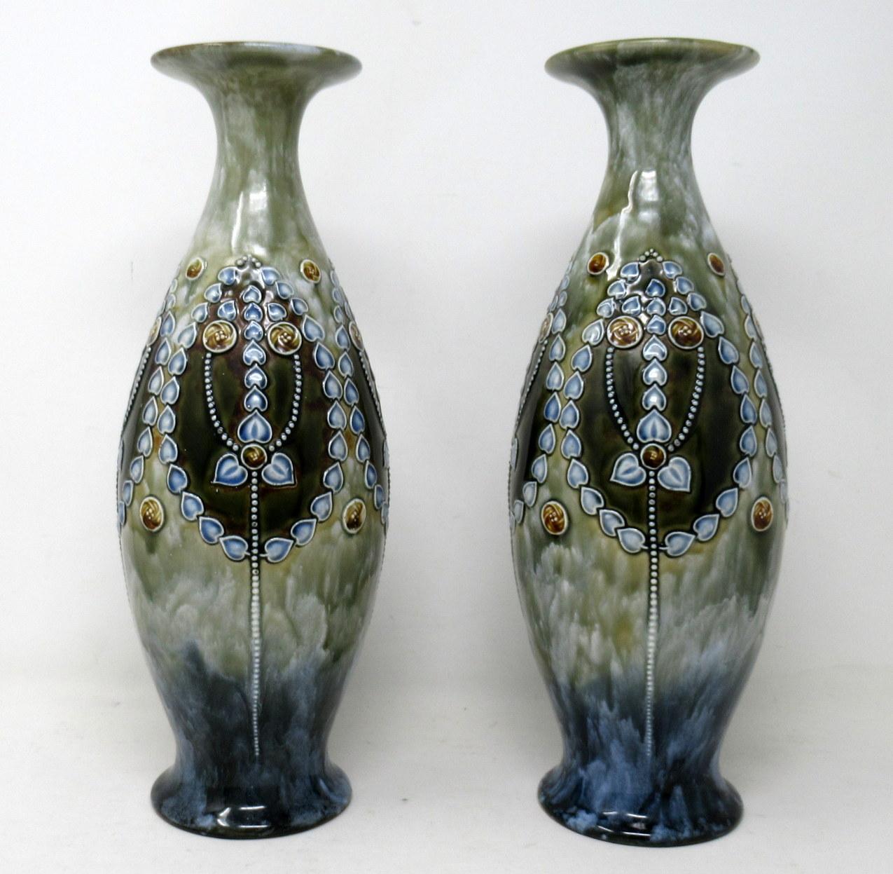 A very stylish Identical pair of English Royal Doulton Lambeth Moulded Salt-Glaze stoneware pottery long neck mantle vases of generous proportions. 

Each of bulbous form with flaired flat formed rims. Lavish Art Nouveau raised tube-line decoration