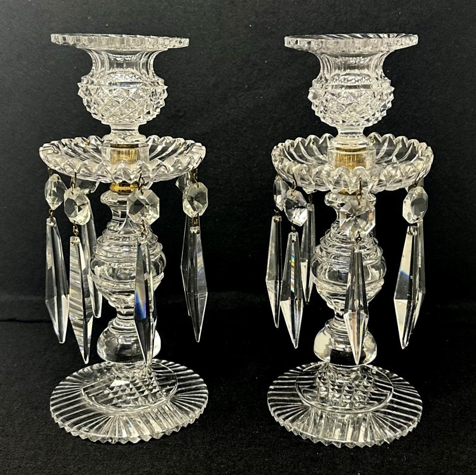 An exceptionally fine example of an early 19th century pair of English Regency neoclassical single light full lead hand cut candlesticks lustres with crisp diamond cut bulbous columns above circular star cut bases, firmly attributed to John Blades