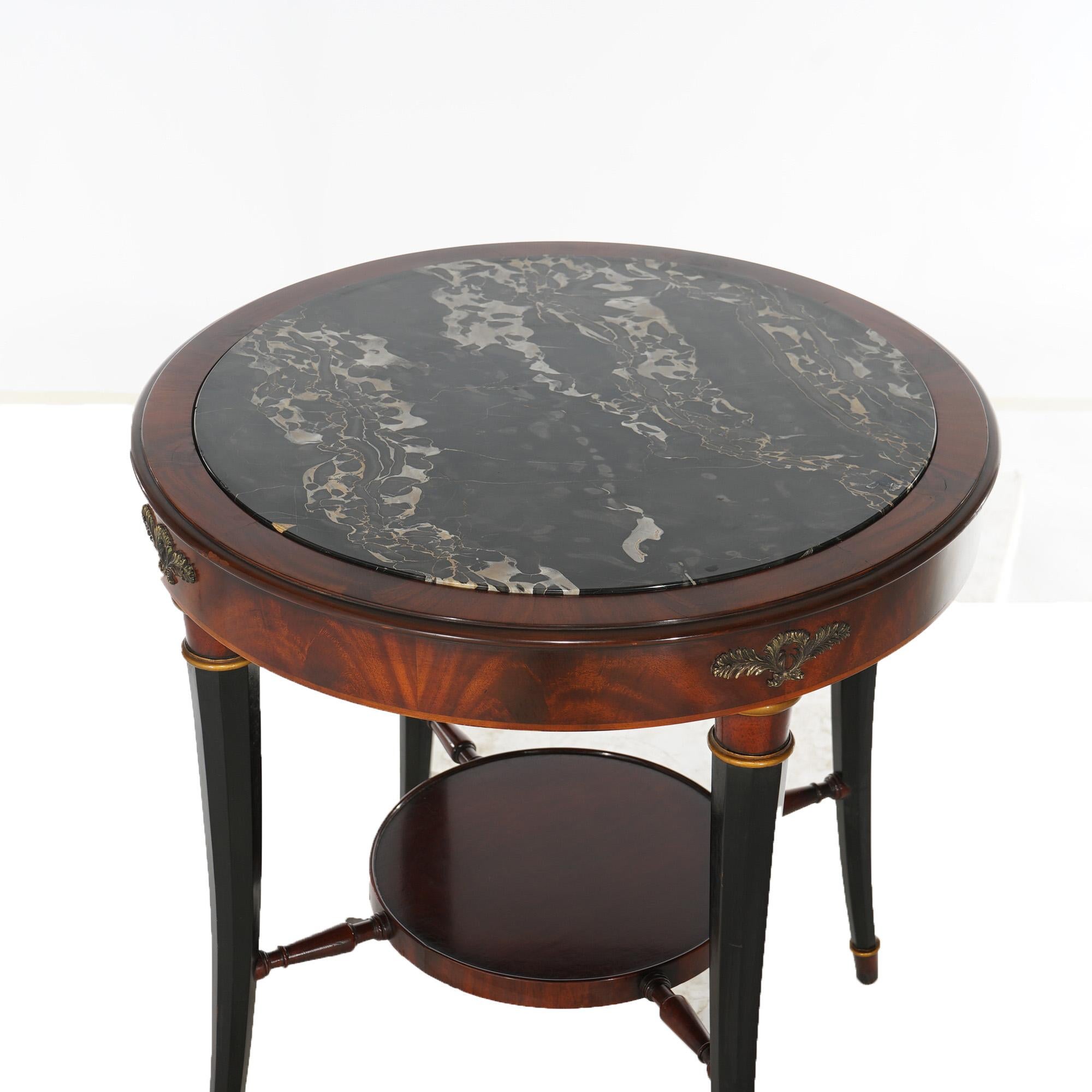 An antique pair of English Regency side tables offer flame mahogany construction with inset marble top, foliate cast bronze mounts, lower circular display and raised on ebonized faceted slightly splayed legs, c1920

Measures - 28