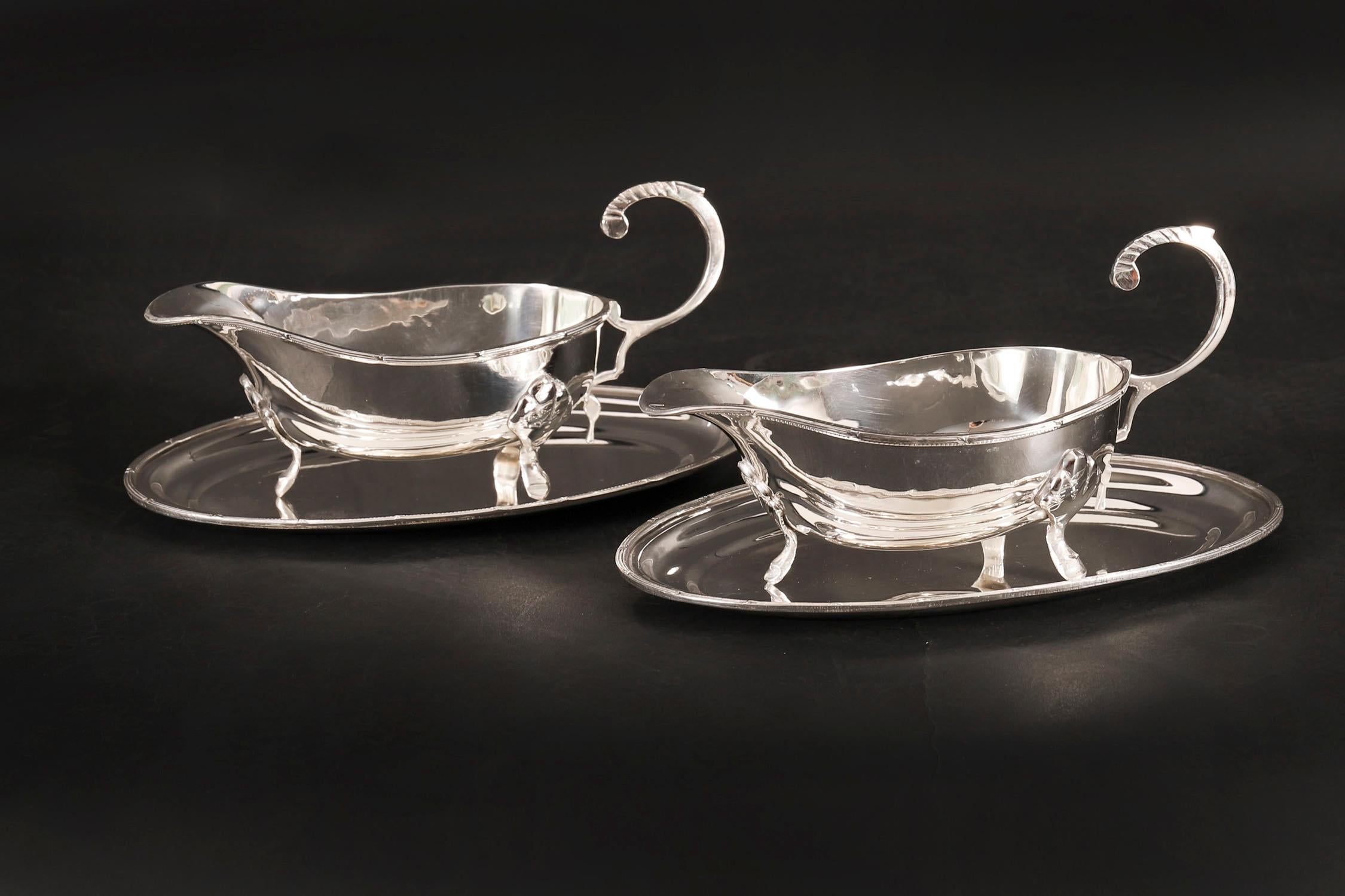Paire de saucières anciennes de style édouardien sur pied, datant de 1910 environ.

Ils sont dotés de poignées classiques à décor ciselé et reposent sur des pieds à pad en forme de sabot et sur des salières ovales en métal argenté.

La qualité et le