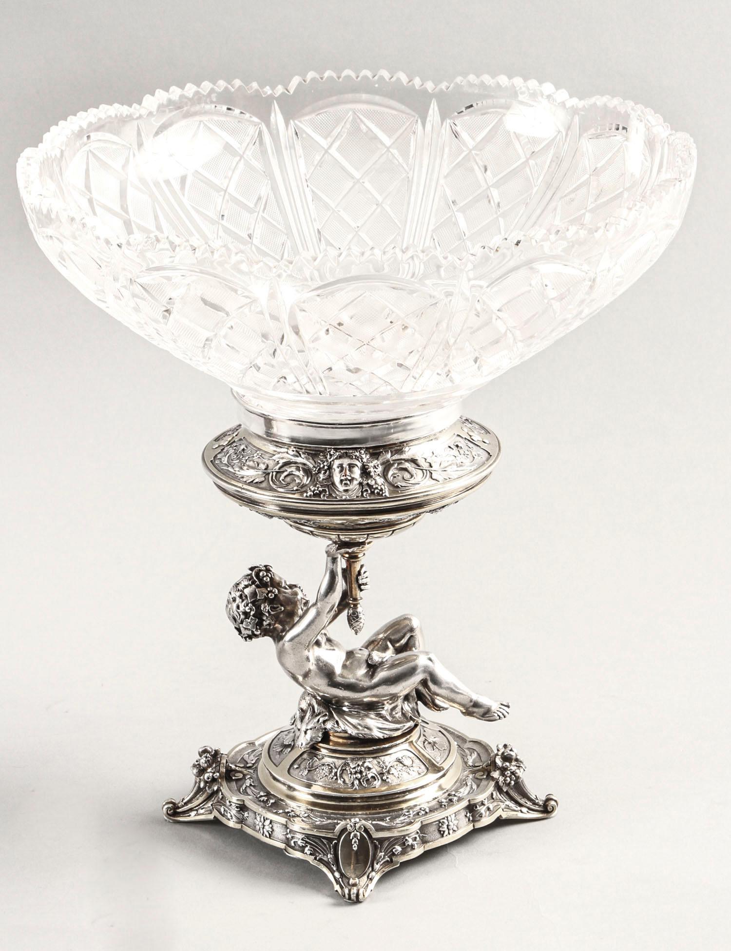 This is an intricate and exquisitely made antique pair of English Victorian parcel gilt silver plated and cut glass centrepieces by the renowned silversmiths Elkington & Co., dated 1883.

Each of these stunning centrepieces has a wonderful central