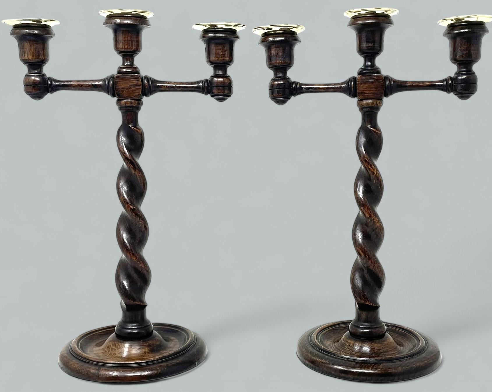 An Exceptionally Stylish Pair of late Victorian Polished Oak Three Light Candelabra of English origin, complete with their original polished brass drip pans. 

This magnificent pair of Candelabra with twin outswept decorative arms, complete with
