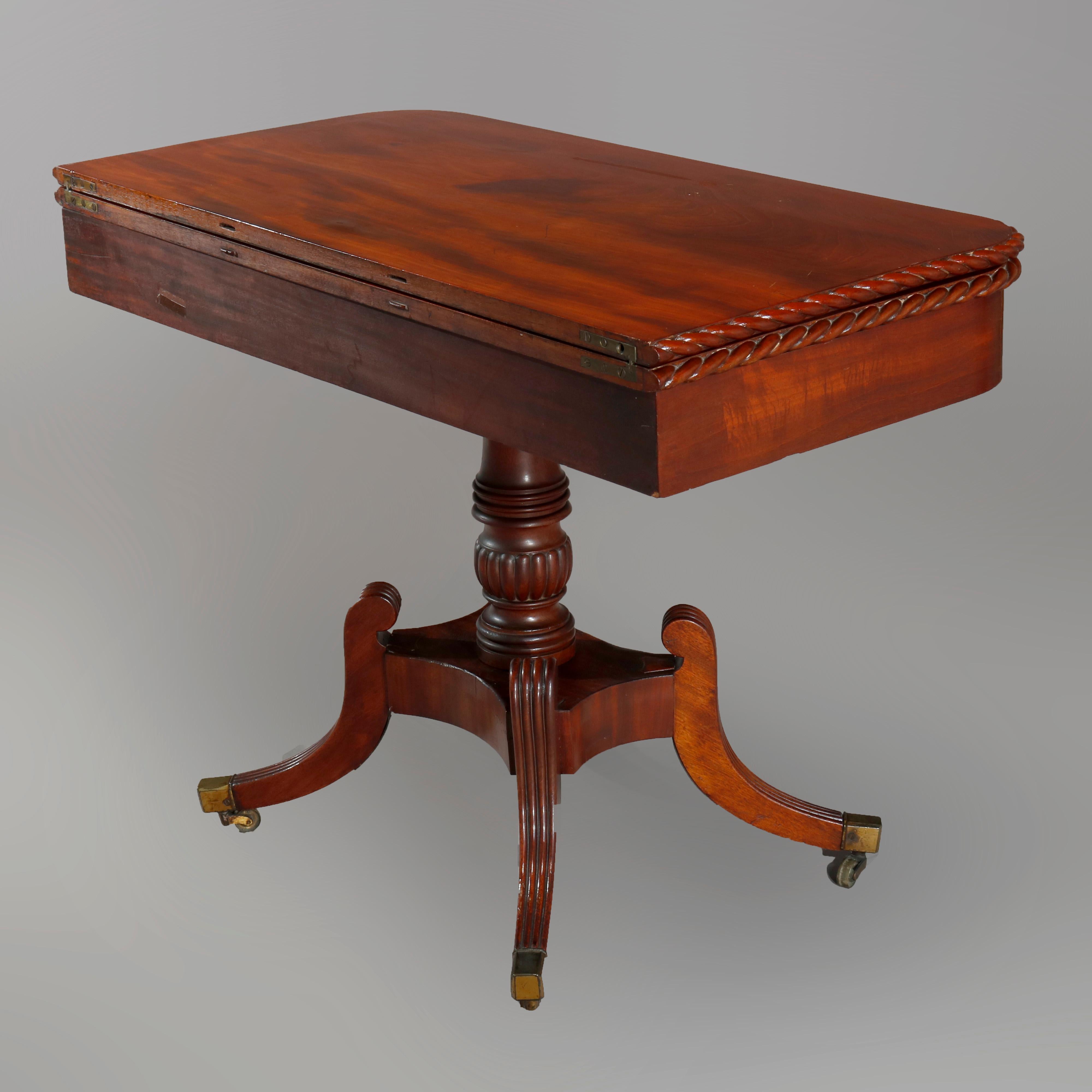 An antique matching pair of Federal game tables offer flame mahogany construction with rope twist edge over deep skirt raised on balustrade columns with quadruped splayed legs terminating in bronze caps with casters, c1820.

Measures: 29.5