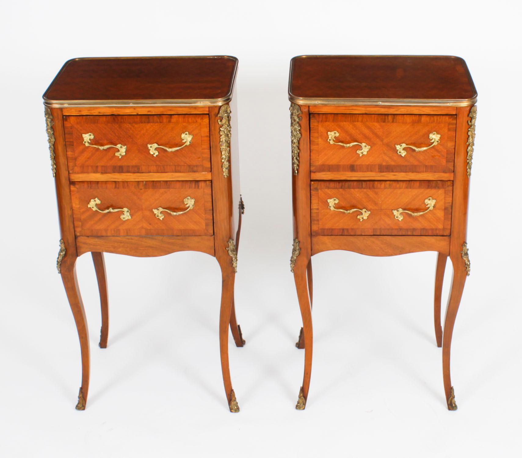 This is an elegant pair of Antique French Bois de Violette and ormolu mounted Louis XVI Revival bedside cabinets, circa 1870 in date.
 
They feature shaped ormolu banded rectangular tops with parquetry decoration. They each have two drawers that are