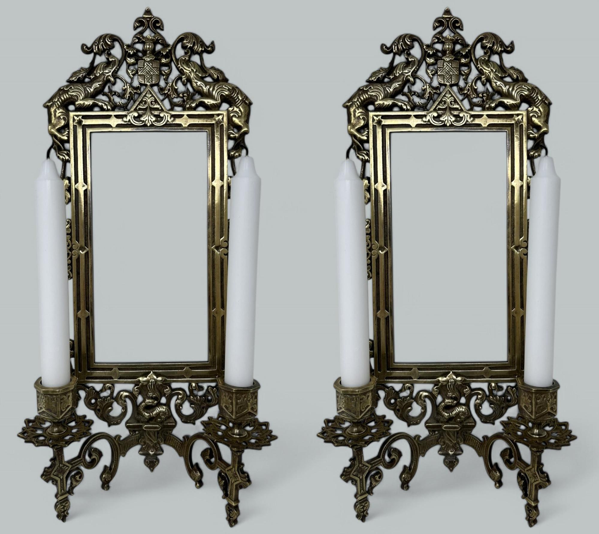An absolutely stunning and quite rare pair of framed French or English Polished Brass Girandole Wall Mirrors in the Neo-Classical taste, of compact size and exceptional quality. Mid the late Nineteenth Century. 

Each enclosing looking glass and