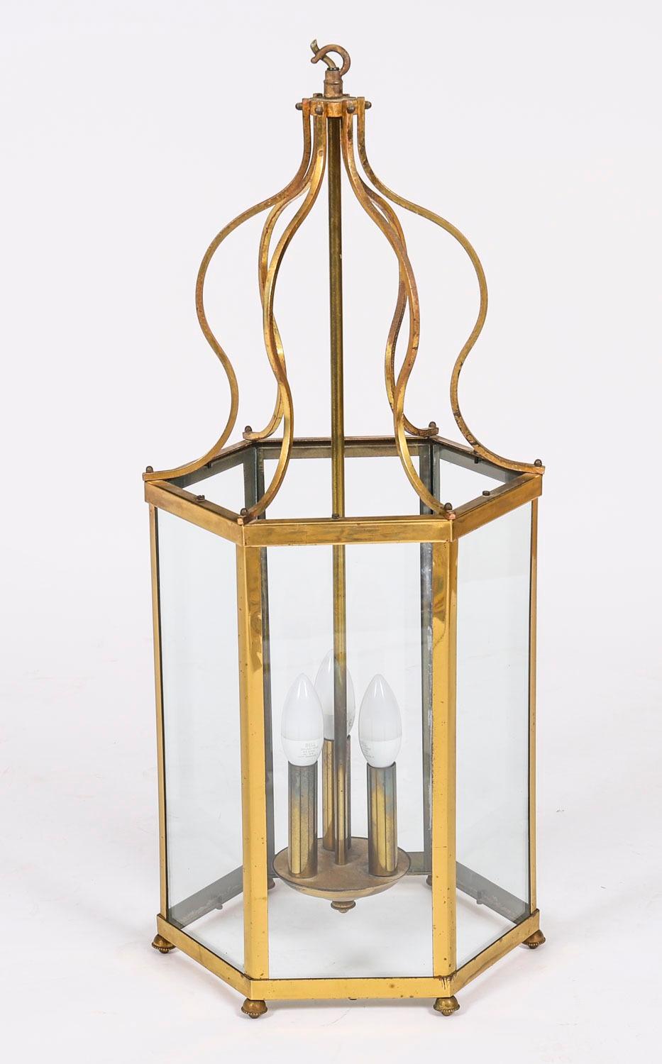 Antique pair of French brass glazed hall lanterns, circa 1900 in date.

The hexagonal pair of lanterns each feature six rectangular glazed sides, set within a brass frame supported by six scrolling brackets from a ceiling mount. The lanterns each