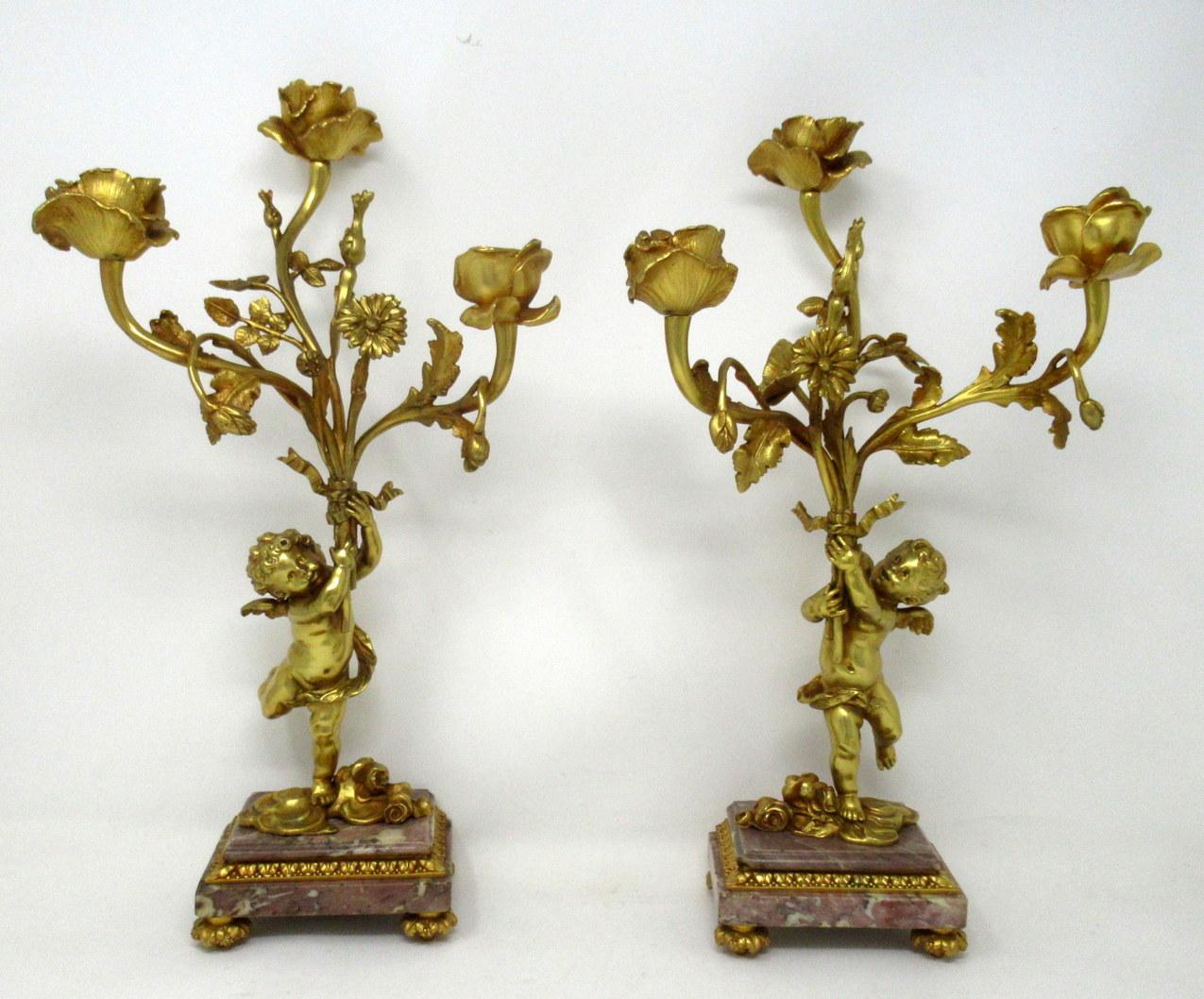 A fine pair of stylish and imposing French Ormolu and Breche Violete three light table or mantle candelabra of outstanding quality, mid-late 19th century. 

Each with a central standing ormolu solid bronze Cherub holding a loft a three-branch