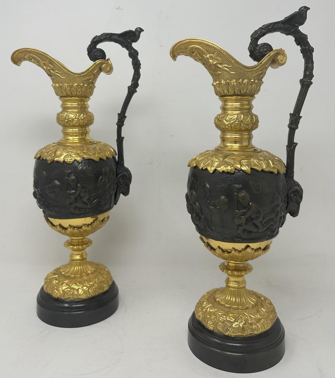 Fine Identical Pair French Heavy Gauge Ormolu & Bronze Ewers of medium proportions and of outstanding quality, in the manner of Claude Michel Clodion, third quarter of the Nineteenth Century. 

The tapering ovoid body cast with a Bacchic procession