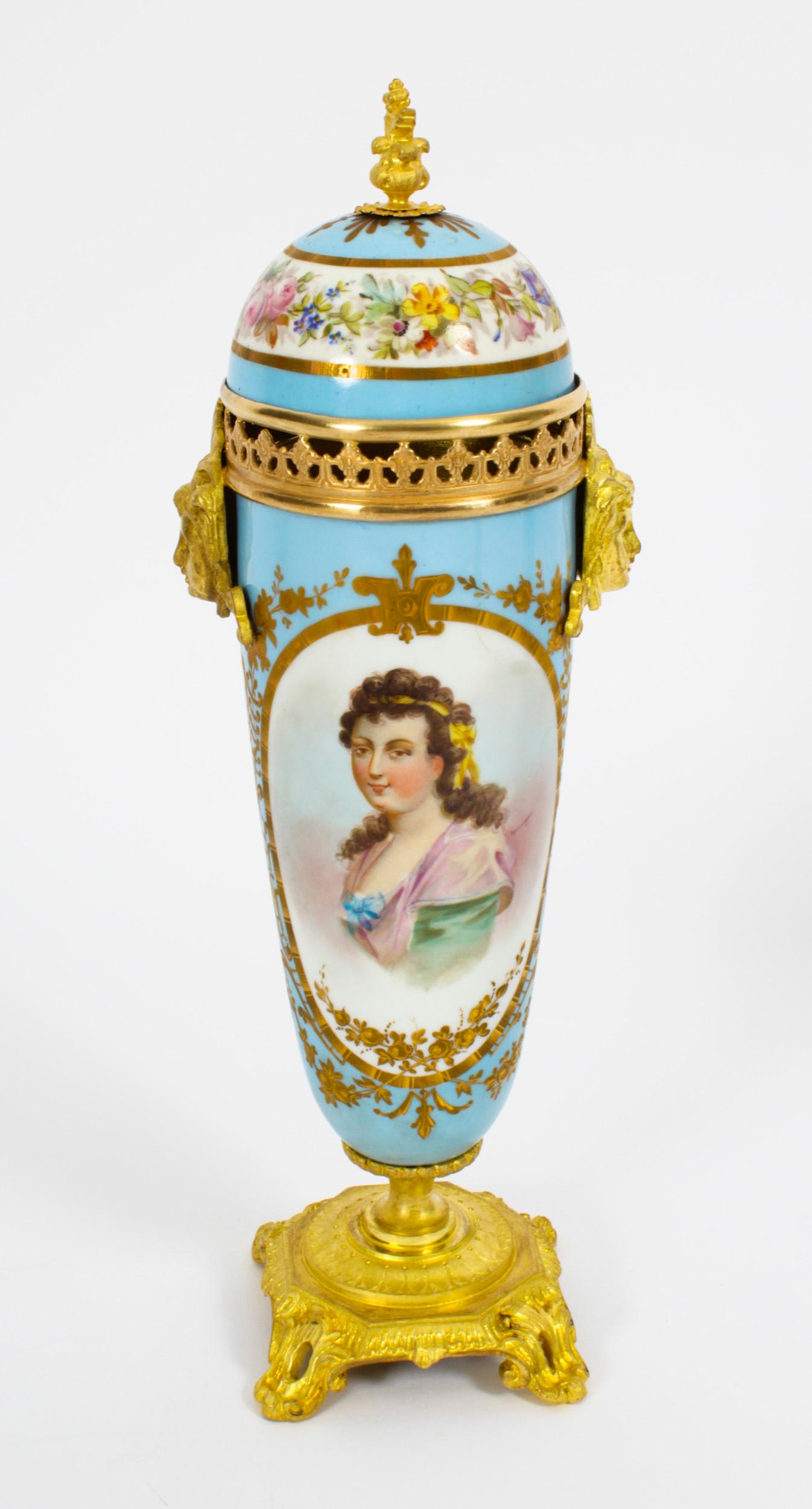 This is a beautiful antique pair of French Sevres porcelain twin masque head handled lidded urns with dome lids, in the Louis XV manner, Circa 1870 in date.
 
The vases with a duck egg bleu ground are superbly decorated with oval panels of busts