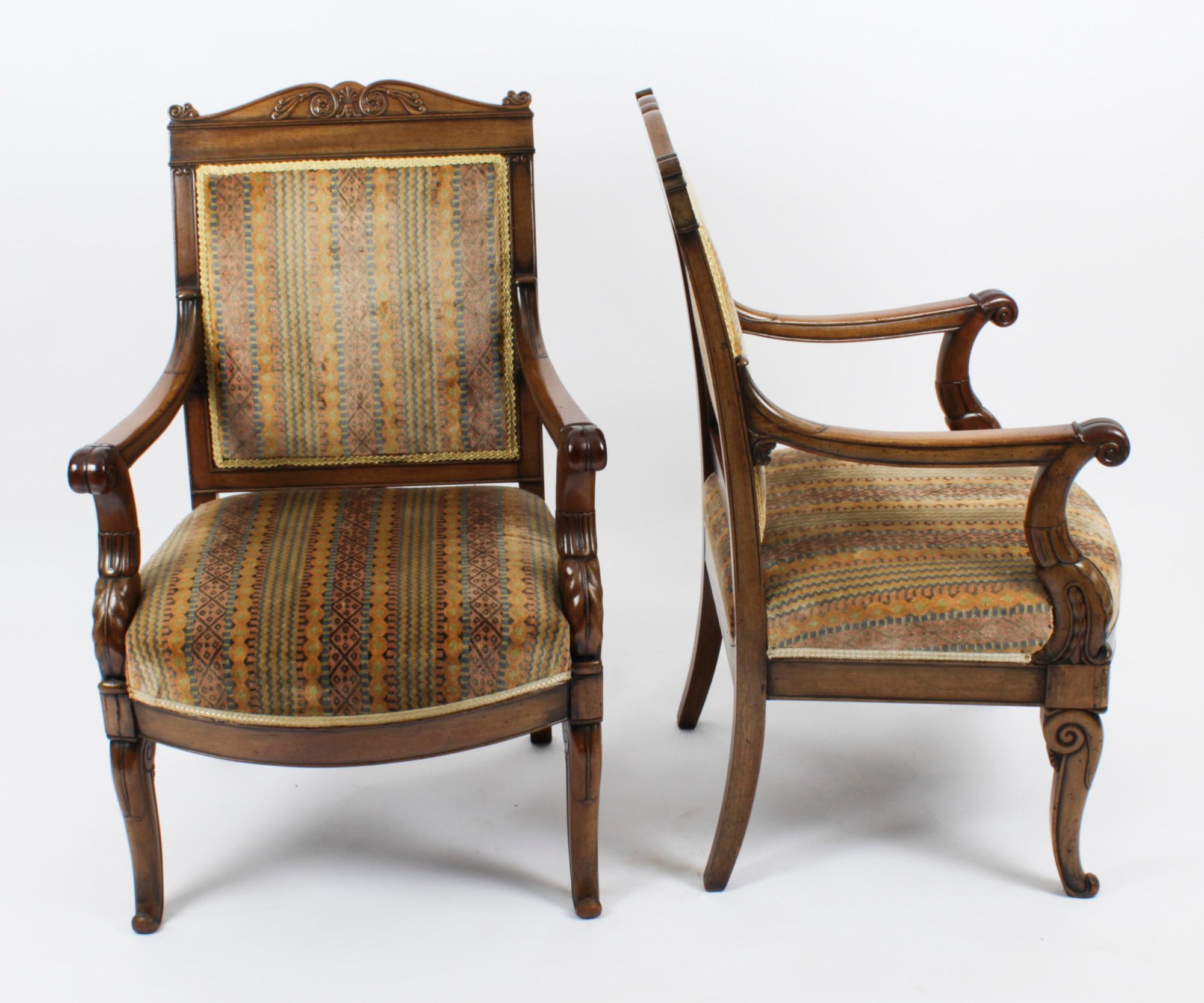 This is an elegant antique pair of French Empire Revival upholstered back mahogany armchair fauteuils, circa 1880 in date.

The mahogany is beautiful in colour with superb patina. The carved top-rails feature scrolling paterae and anthemion above