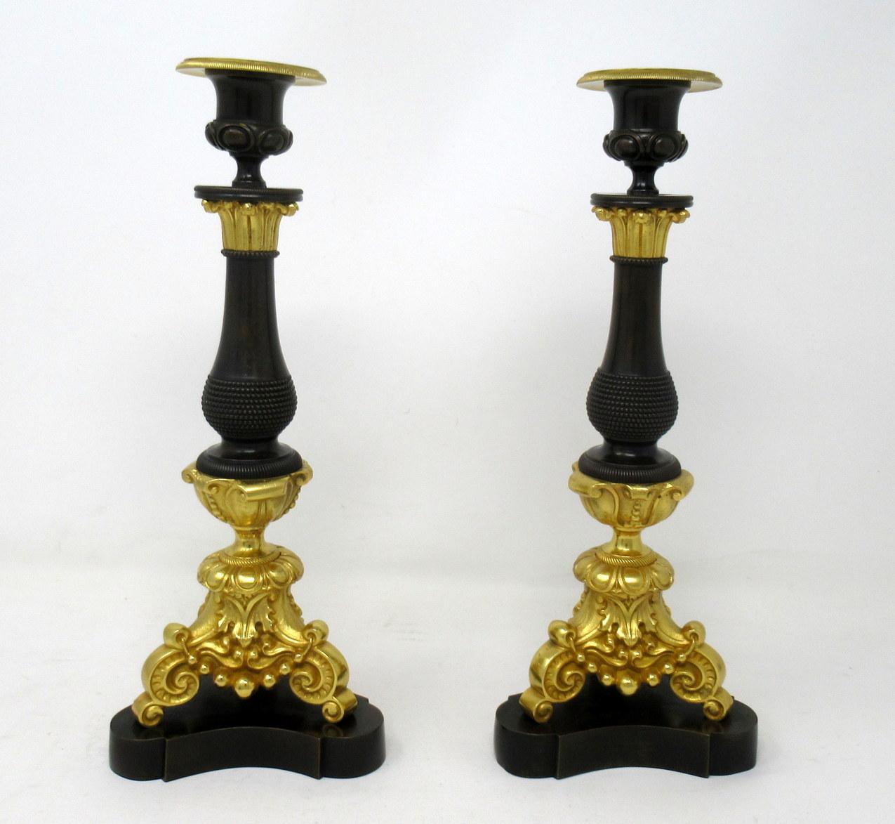 An exceptionally fine pair French Ormolu and bronze single light candlesticks of medium size proportions, each with unusual bulbous central bronze columns, ending with three monopodia supports with scroll feet, on tri-form concave sided plain bases,