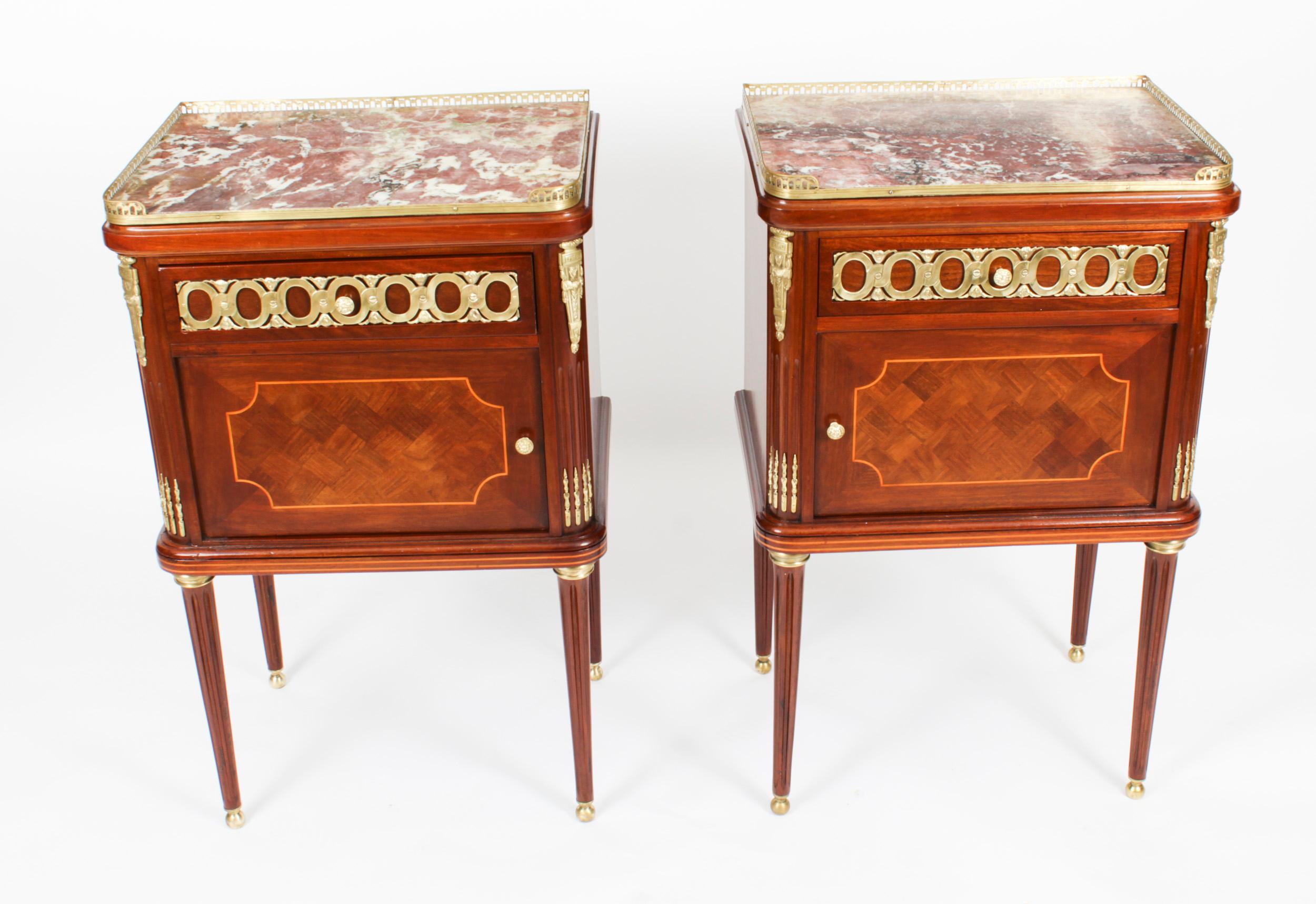 A thoroughly delightful pair of antique French ormolu mounted walnut and parquetry bedside cabinets, circa 1880 in date.
 
They each feature rectangular mottled Rouge de Rance marble tops with three quarter brass galleries above oak lined drawers,