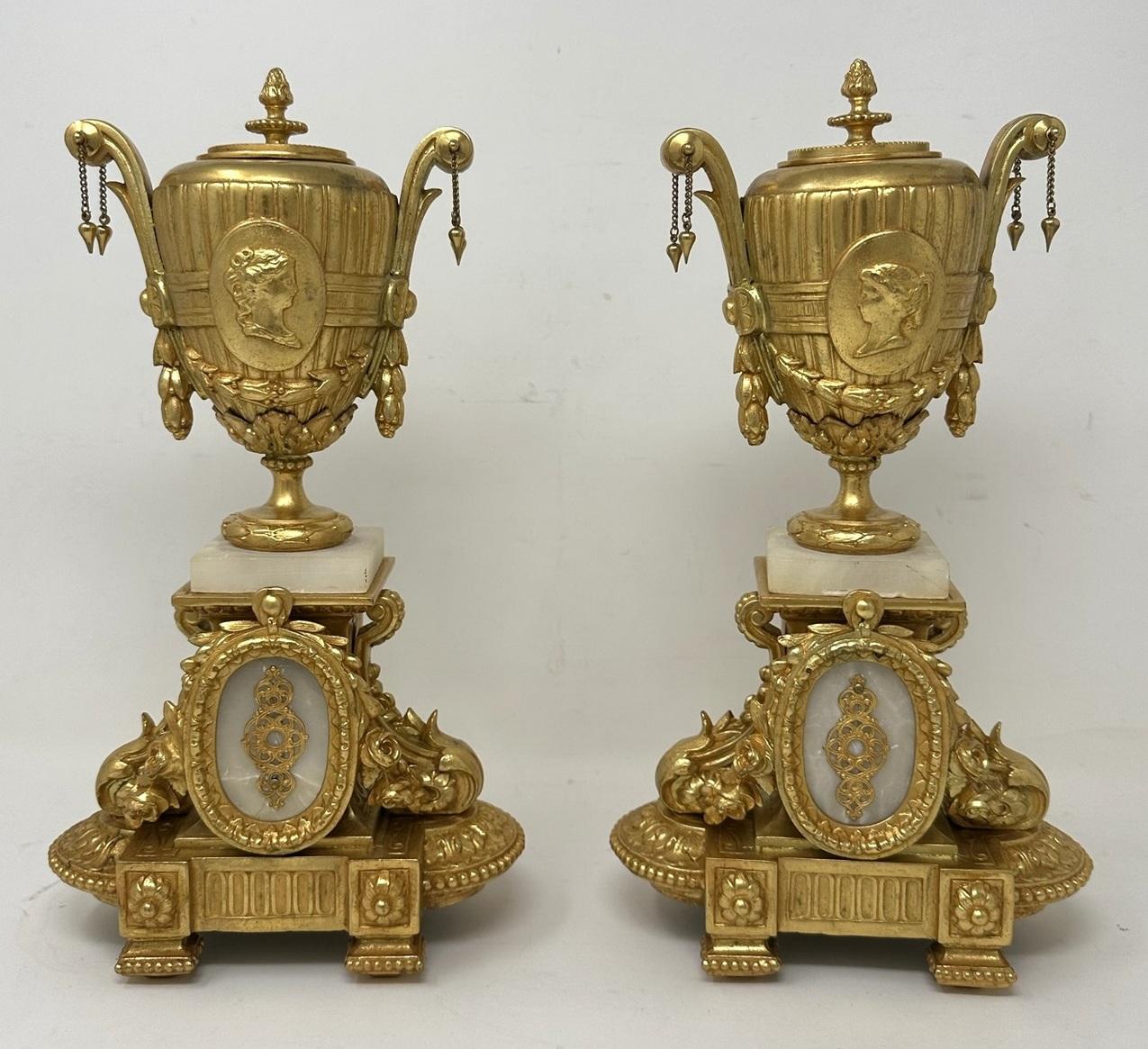 Wonderful Pair of French Gilt and Alabaster Twin Handle Cassolettes or Single Light Candlesticks of generous proportions. Last half of the Nineteenth Century. 

The unusual decorative handles with hanging chains on a traditional urn with a central