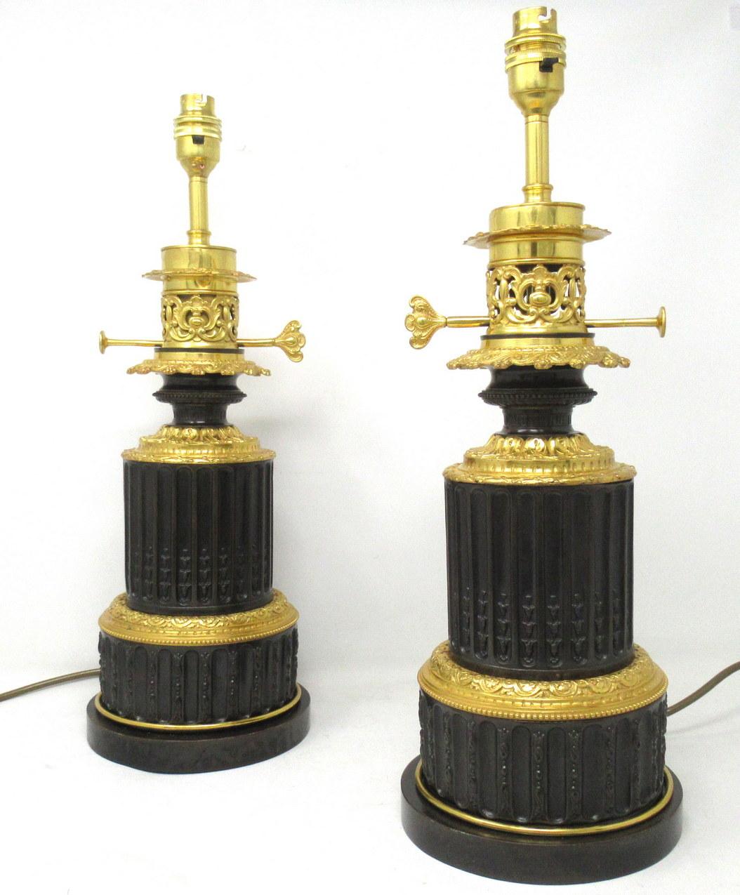 An exceptionally fine pair french finely cast patinated dark brown bronze fluid oil table lamps of generous proportions, depicting an all-round fluted detail central body with stylish beaded rims, now converted to electricity.

The original ormolu
