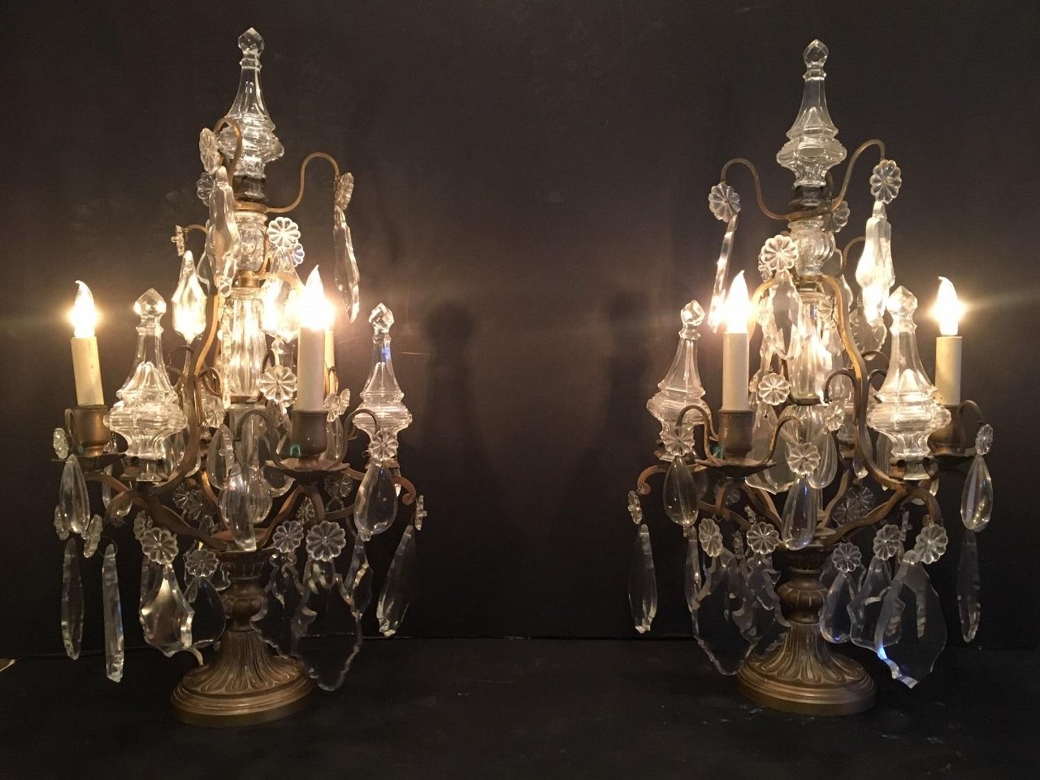This pair of three light candelabras, crafted in fine cut glass,  were created in France at the turn of the century.  The stunning Girandoles have a clear crystal blown glass sections in the center. Bronze arms hold a beautiful array of clear