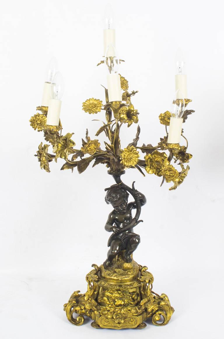 A large fine antique pair of French ormolu and patinated bronze six-light table candelabra, circa 1850 in date.

The stylised patinated bronze cherubs are seated on a finely cast ormolu plinth bases that are ornately decorated with garlands of