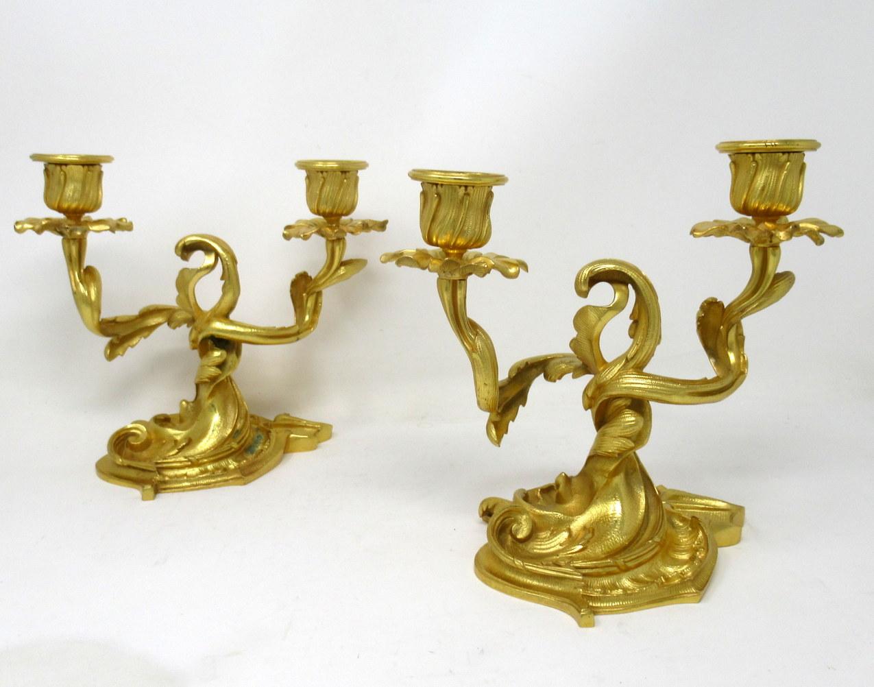 A very stylish pair of twin light gilt heavy gauge gilt bronze ormolu table or mantle candelabra in George III Style, last quarter of the 19th century, of French origin. 

Each with central rococo style finial and two scrolling leafy out swept