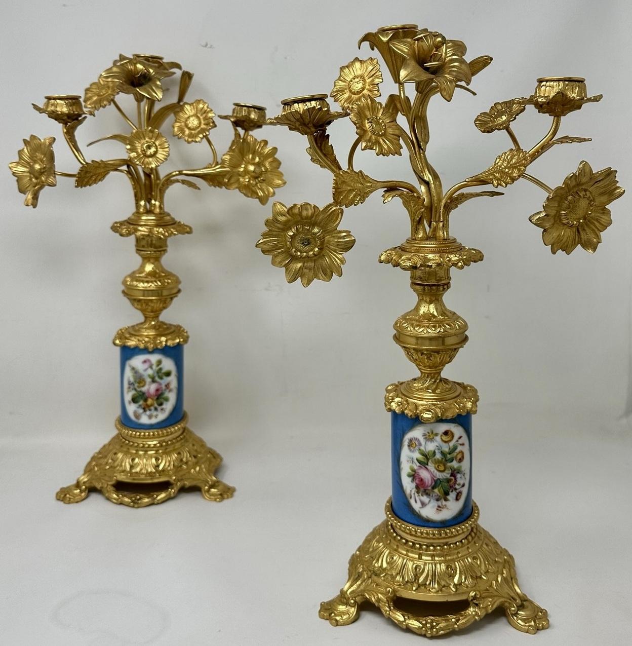 Paire de candélabres de table ou de cheminée en porcelaine de Sèvres à trois lumières, montés sur bronze doré, d'une qualité exceptionnelle et d'un style imposant. Milieu ou fin du XIXe siècle. 

Chacun avec trois branches en volutes avec diverses