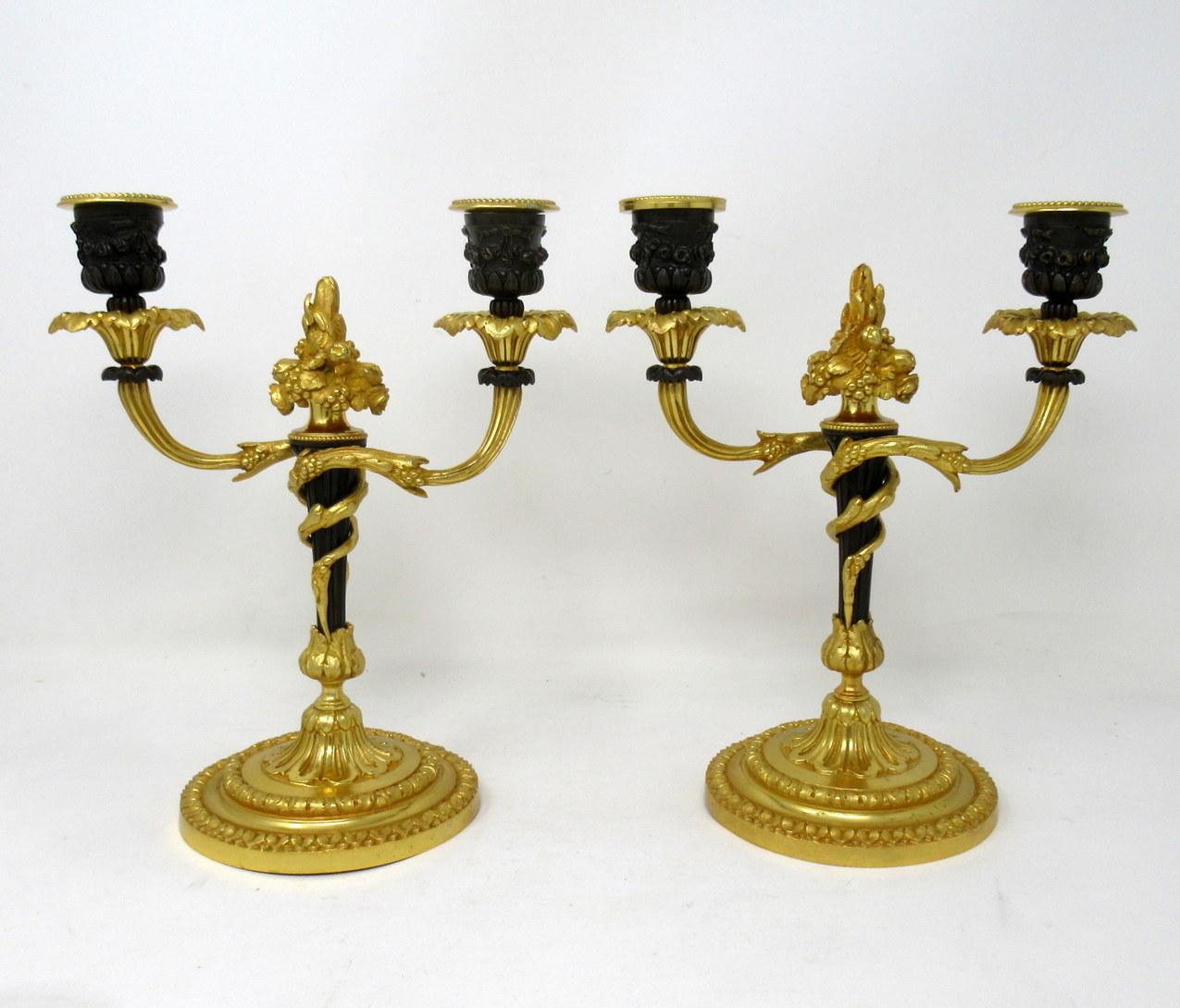 A very stylish pair of twin light chisel cast gilt bronze table or mantle candelabra in George III style, last quarter of the 19th century, of French origin. 

Each with central naturalistic finial and two leafy scroll out swept arms above a central