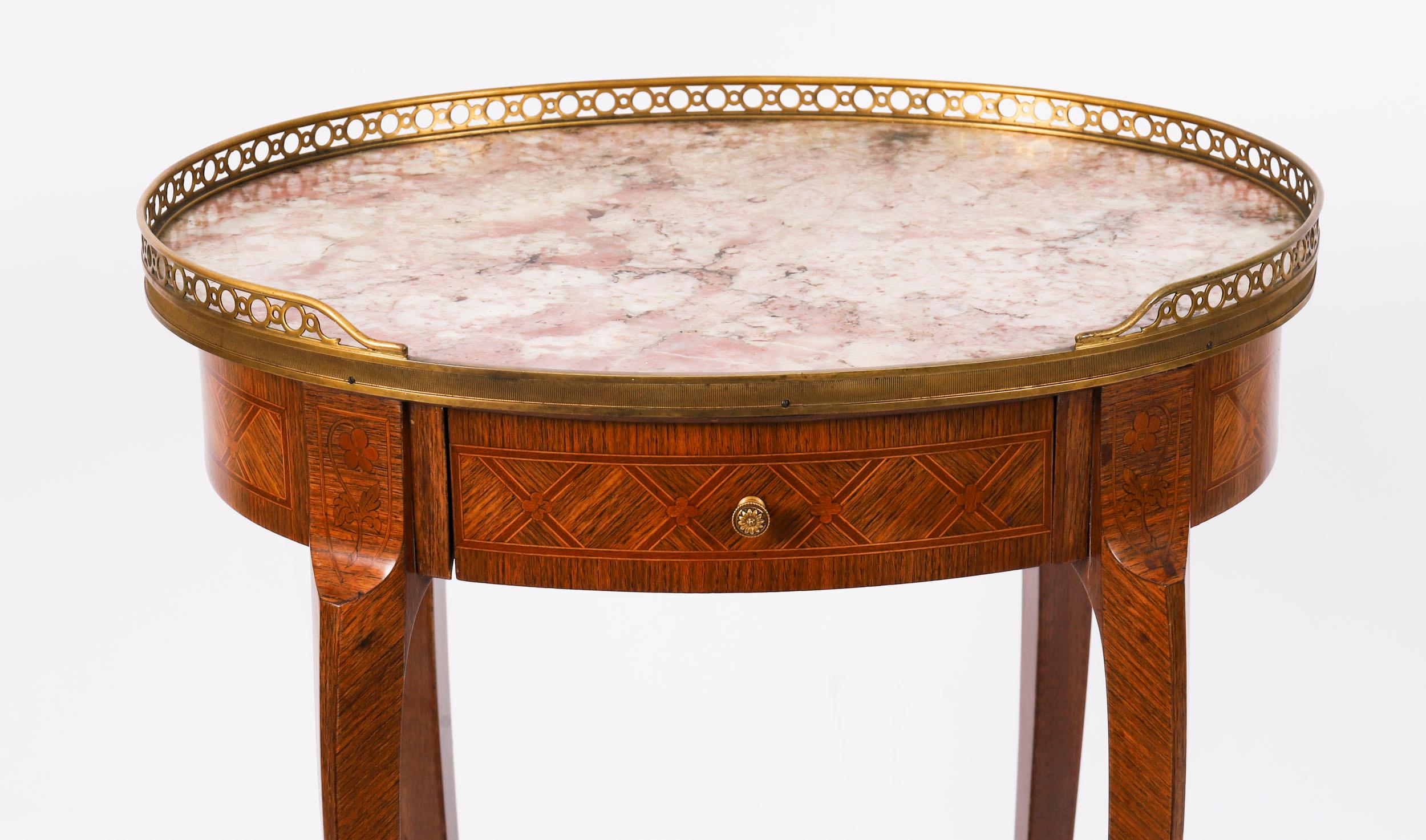 Il s'agit d'une belle paire de tables d'appoint anciennes en bois et parquet de style néo-louisianiste français, datant de la fin du 19e siècle.
 
Les plateaux des tables rondes en marbre Rouge Griote à bandeau de bronze doré sont surmontés de