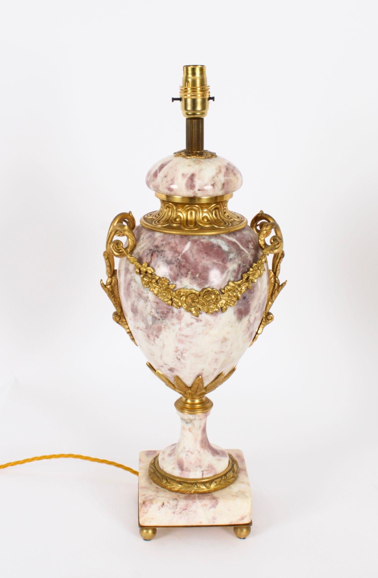An antique pair of French Louis XVI Revival ormolu mounted pink and white Variegated marble Neo Classical table lamps, Circa 1860 in date.

The pair are of baluster form with twin scroll ormolu handles and ormolu cartouches, raised on circular