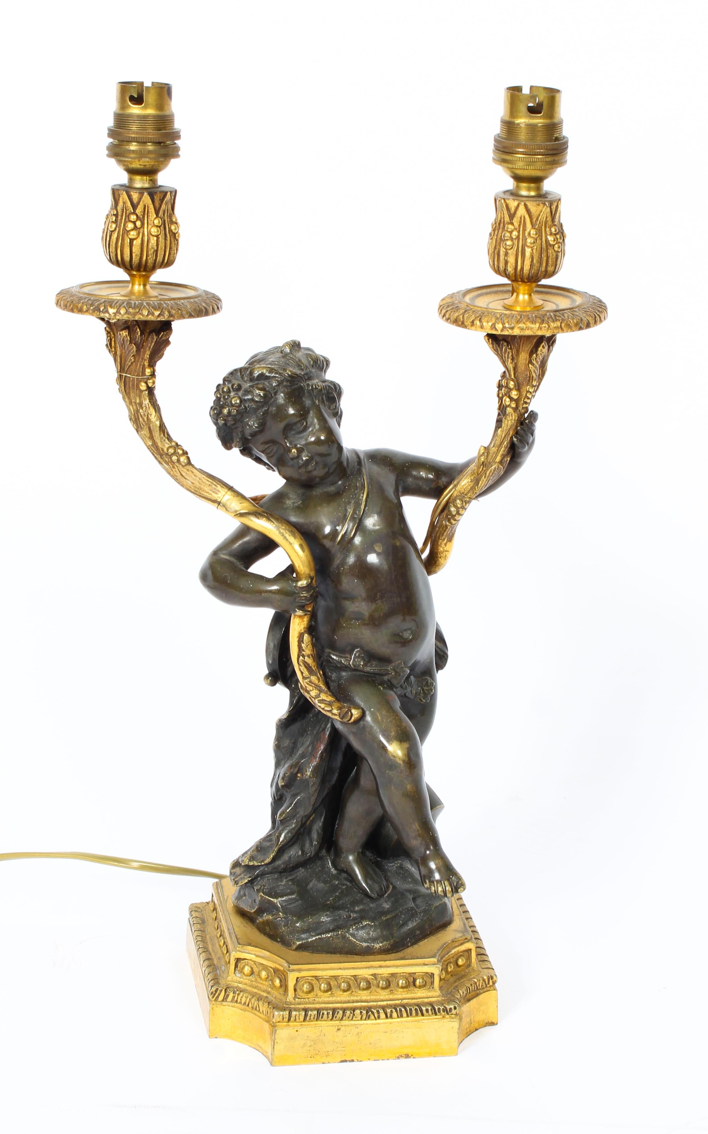 A magnificent antique pair of French ormolu and patinated bronze two light table lamps, circa 1860 in date.

They are superbly decorated with foliate scrolls and stunning patinated bronze Bacchic cherubs holding cornucopia shaped arms decorated