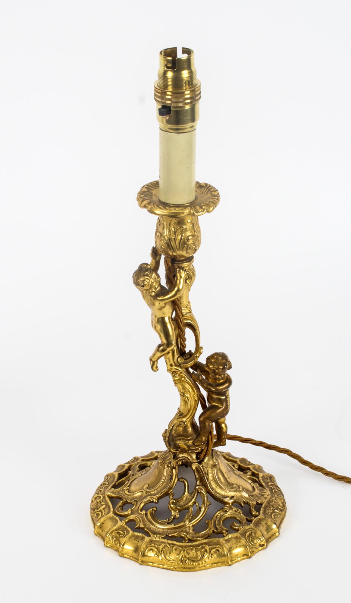 A magnificent antique pair of French ormolu table lamps, Circa 1870 in date. 

Later converted to electricity from 19th Century French ormolu candlesticks. The stems formed as climbing cherubs and rococo decoration upon naturalistically modelled