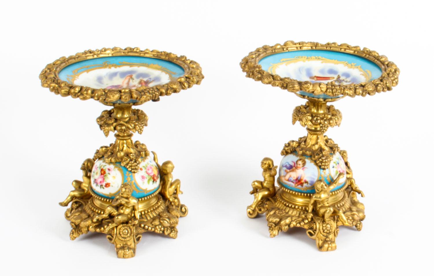 This is a impressive pair of antique Sevres Bleu Celeste Porcelain tazza's with ormolu mounts, circa 1880 in date.

The shallow circular dishes feature hand painted cherubs on a bleu celeste ground with gilt high lights and decorative ormolu mounts