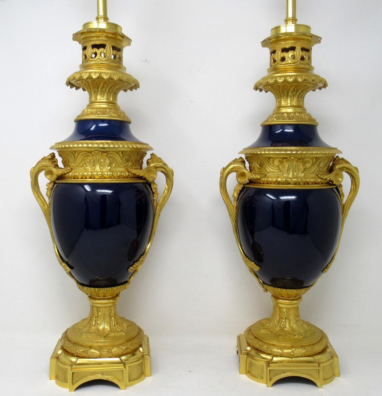 An exceptionally fine pair of heavy gauge French Glazed Porcelain oil lamps of impressive proportions, with ornate Ormolu bases now converted to electric table lamps, of good size proportions, mid to early nineteenth century. 

The main Cobalt blue