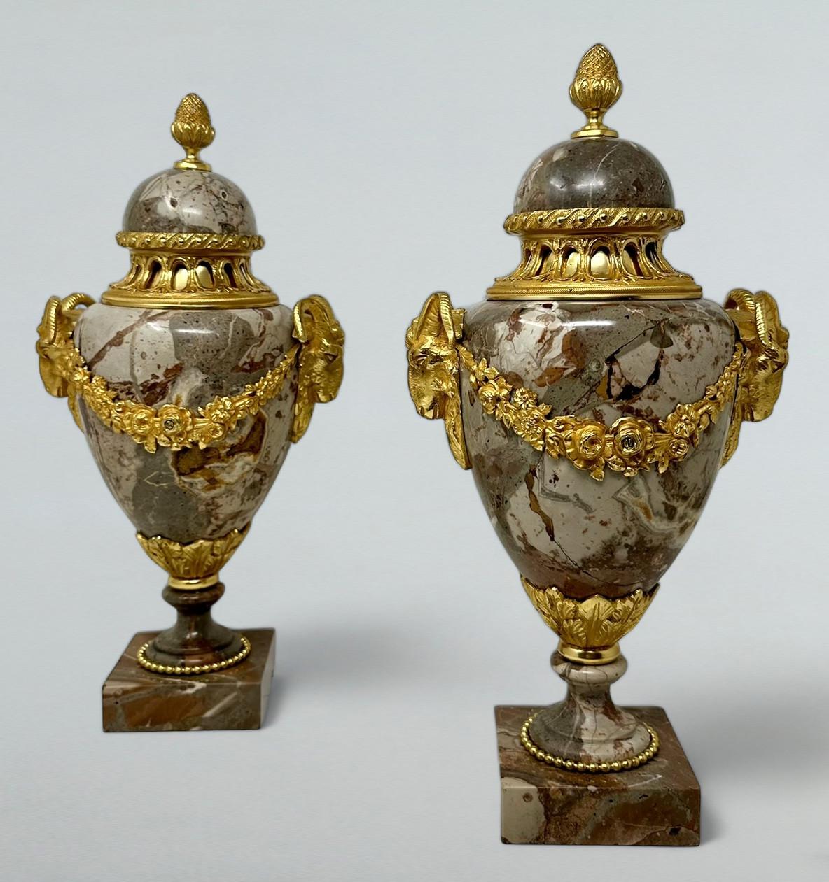 Stunning Example of a pair of French Ormolu mounted well veined Sarrancolin or Brecca Africano Marble Twin Handle Urns of museum quality, after a model by Lean Julienne (1686-1766). Mid to late Nineteenth Century.  

Each exquisitely surmounted by a