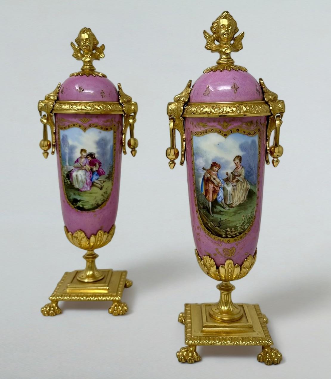 Stunning Pair of French Sevres Soft Paste Enameled Porcelain and Ormolu Twin Handle Table or Mantle Urns of traditional urn form and of outstanding quality, and good size proportions, each raised on a square stepped base with claw feet. Mid