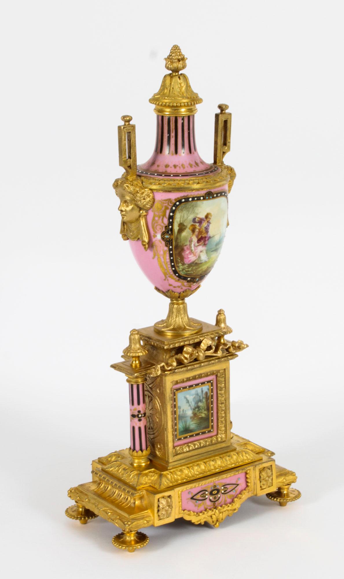 This is a stunning pair of French Sevres porcelain and ormolu garniture urns, circa 1880 in date.

The pink grounds are hand painted with courting couples, one by an arbour, the other fishing in a river, the reverse with landscape scenes.

They
