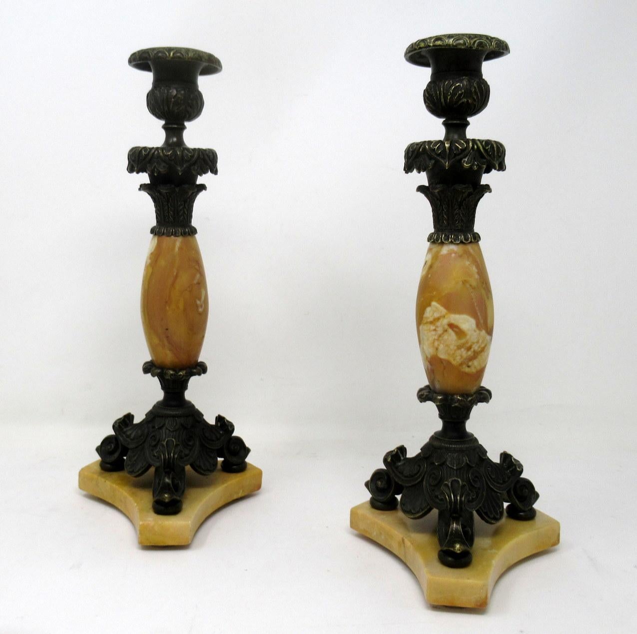 Un'ottima coppia di candelieri da tavolo o da camino a una luce in bronzo patinato e cesellato e marmo di Siena a grana fine, di qualità impressionante. primo quarto del XIX secolo. 

Ciascuna colonna centrale circolare a forma di bulbo sostiene