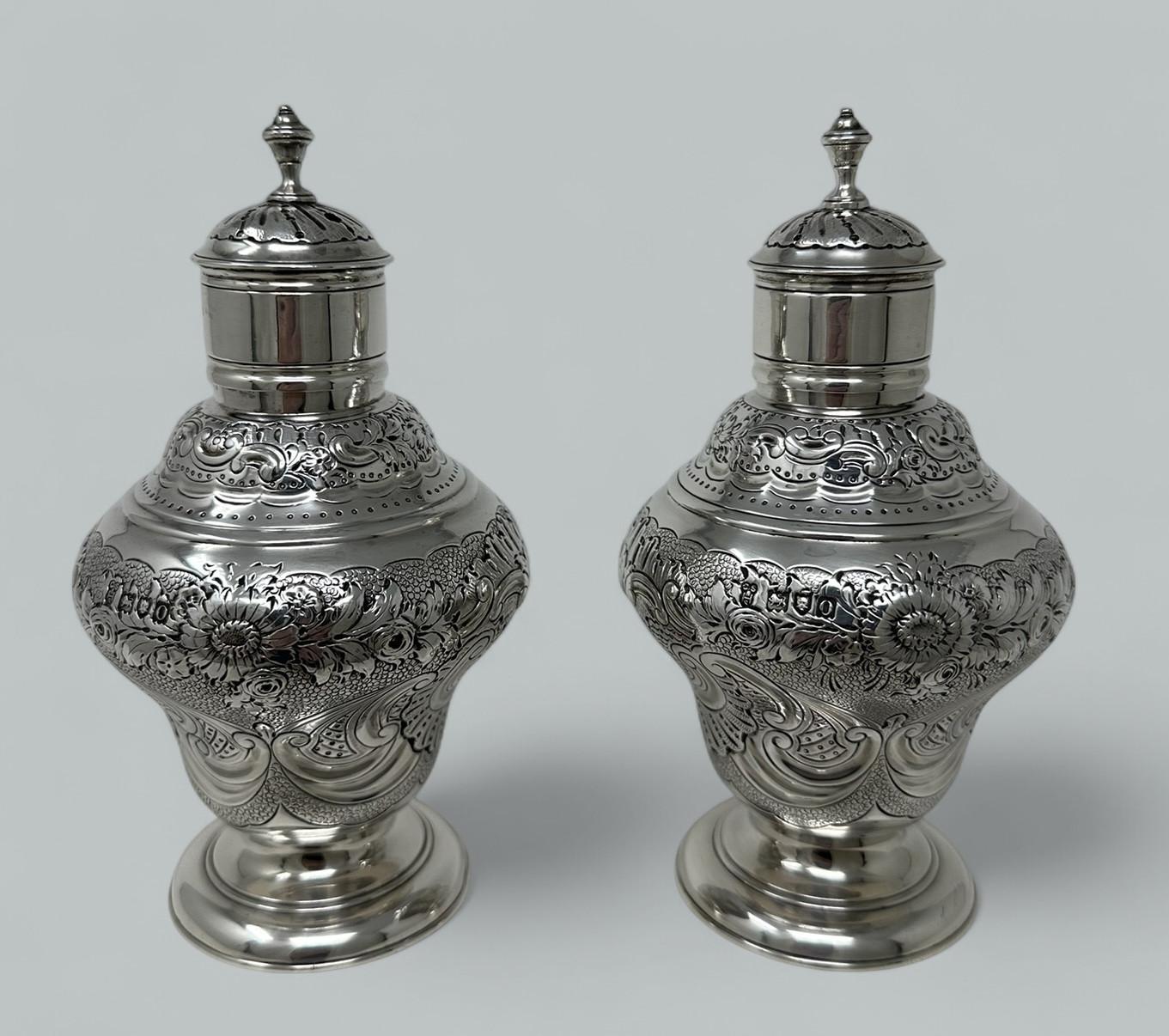 An Absolutely Stunning Identical Pair of English Sterling Silver Eighteenth Century style Tea Caddies early Twentieth Century after an Eighteenth-Century model.  

Rococo style, each with stylish inverted baluster body with decorative floral and “C”