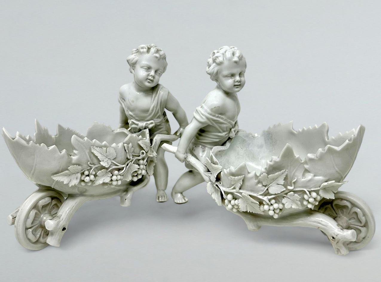 Stunning Example of a pair of German Meissen Blanc de chine Porcelain Centerpieces each modelled as decorative oval baskets been driven by walking cherubs. Late Nineteenth Century.  

Exquisitely decorated with applied bunches of grapes and vine