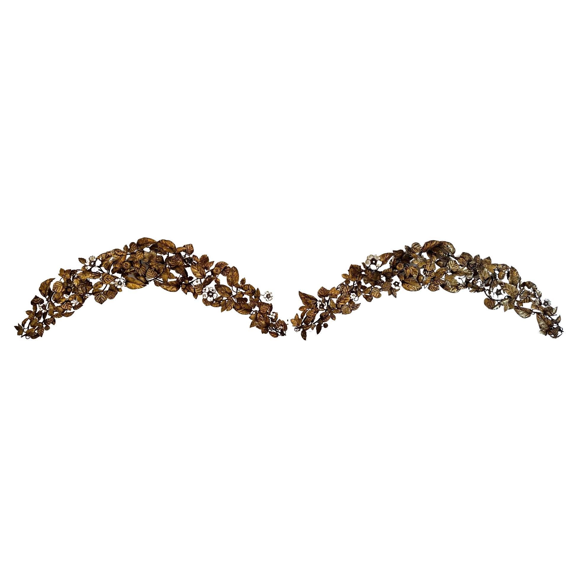 Impressive ornate pair of gilt metal tole boomerang or crescent shaped wall sculptures that make fabulous arches above windows or adornments over doorways. Beautiful aged display of leaves and flowers with 3 dimensionality and wonderful patina.