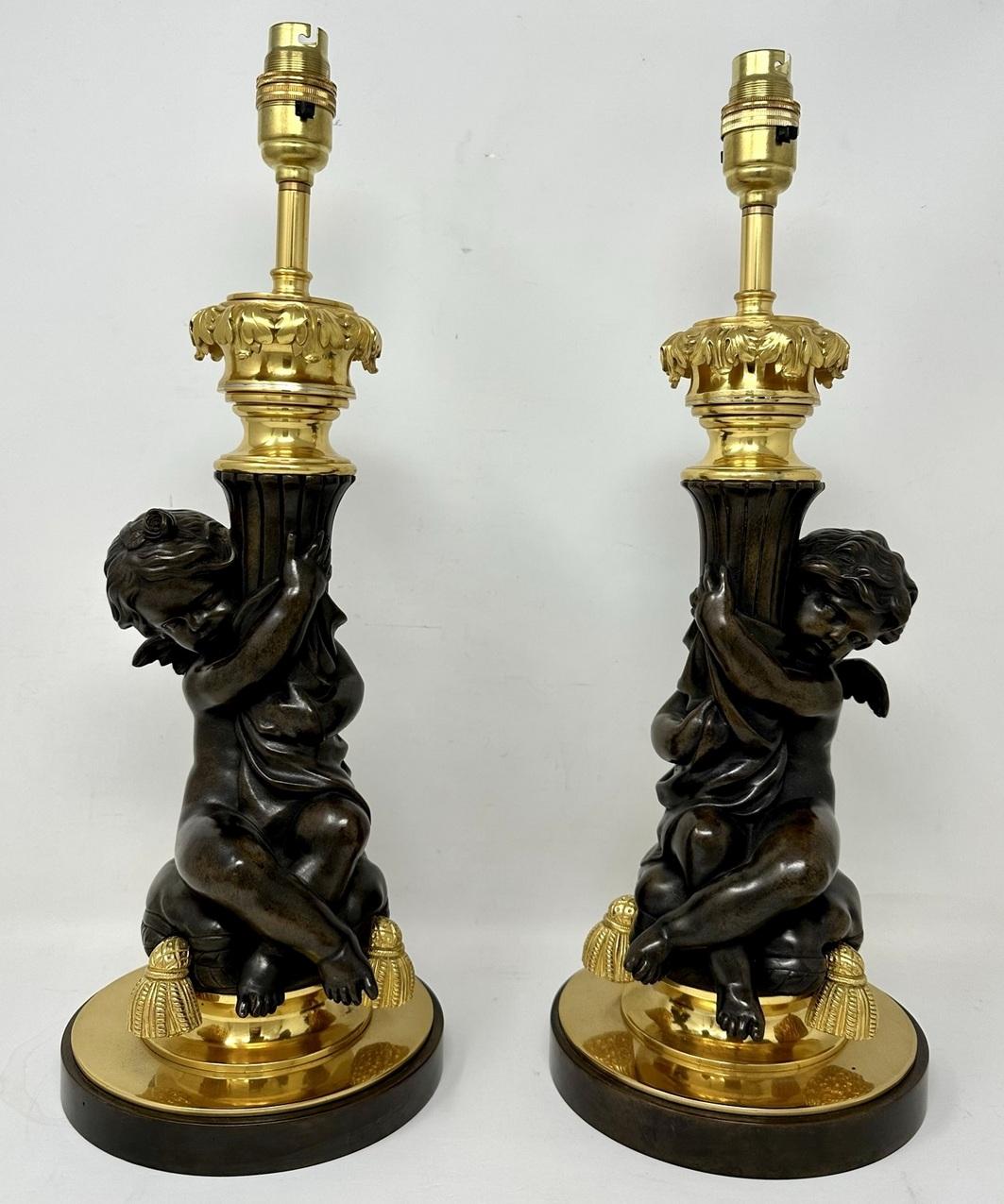 A very fine quality pair of French Louis XV inspired Chisel cast heavy gauge patinated and gilt bronze figural electric table lamps of outstanding quality and good Size proportions depicting Winged Cherub seated on a tasseled pillow holding a