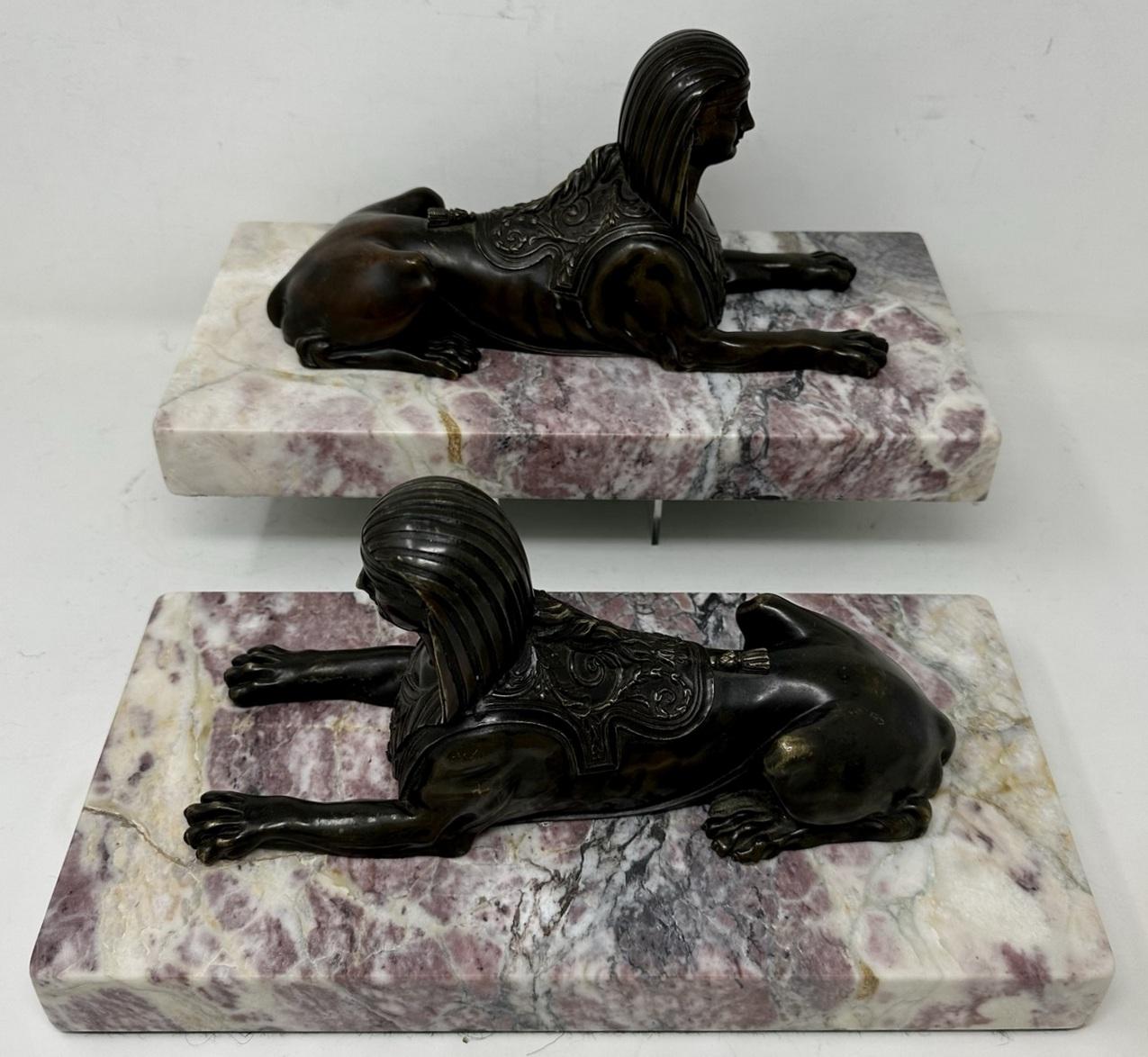 An Extremely Imposing seated identical pair of chisel cast patinated Bronze Egyptian Sphynx, early Nineteenth Century, Possibly Regency period and of French origin. 
Complete with extremely well figured Breche Violet marble rectangular heavy gauge