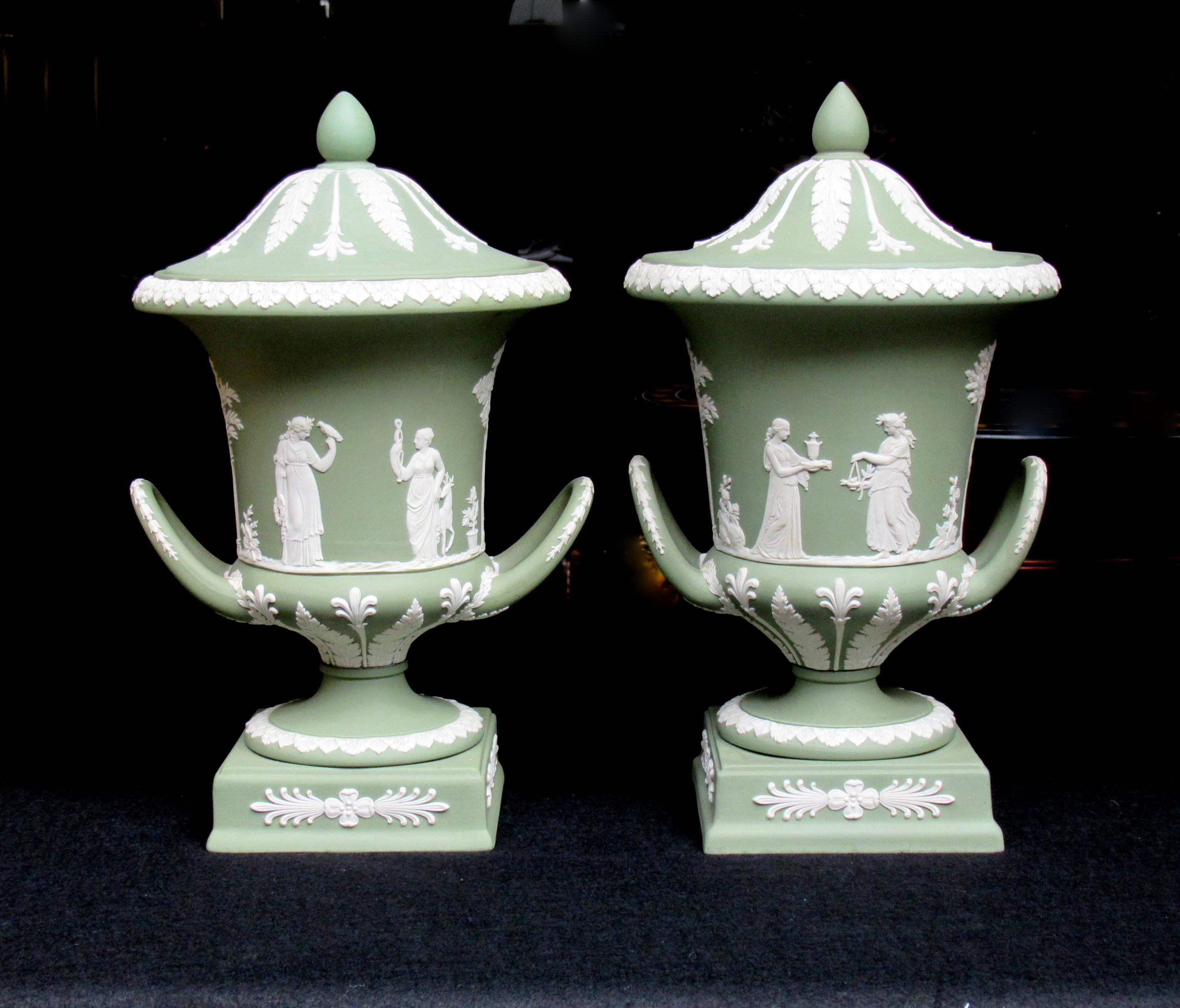 An exceptionally fine quality pair of English Jasperware Wedgwood urns of outstanding quality and condition and good size proportions, circa 1950. 

Each of classical urn form replete with neoclassical floral and foliate decoration depicting