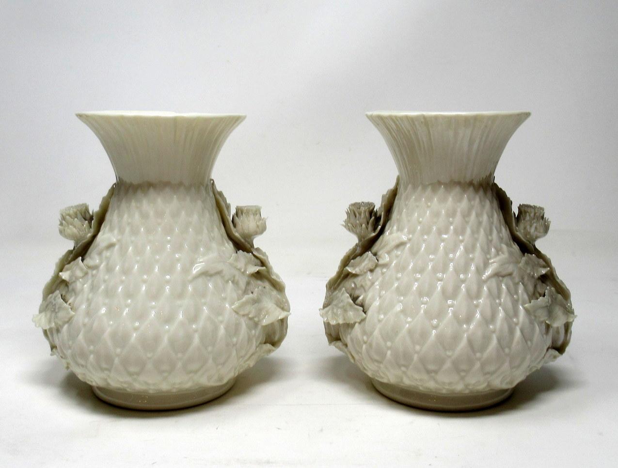 Stylish pair of Irish Belleek porcelain thistle vases of compact proportions. Third black mark for dates 1926-1946.

Each leaf molded body of bulbous outline with applied thistle bud flowers in high relief. The tall slender flared openings with
