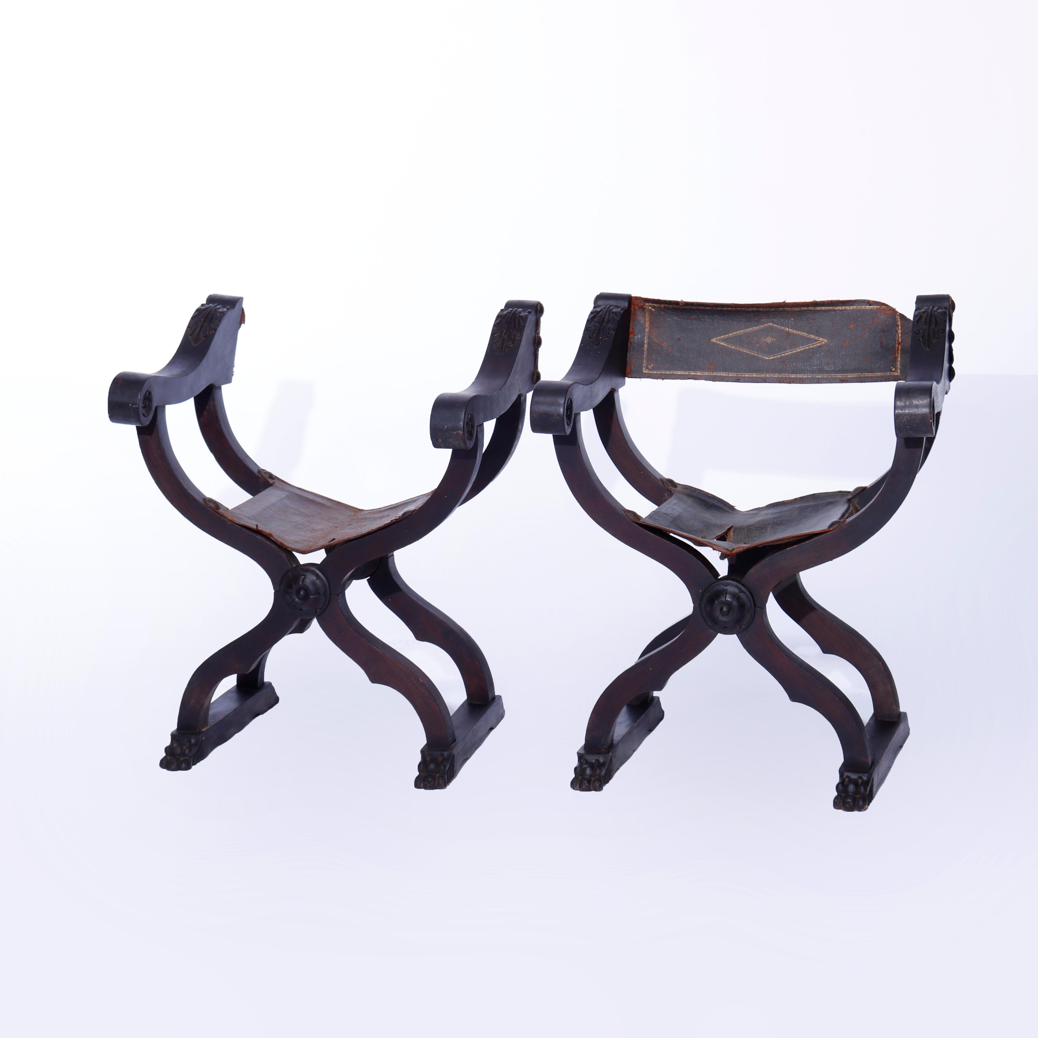 An antique pair of Italian curule folding arm chairs offer walnut construction with carved acanthus on scroll form arms, rosettes, carved paw feet and having leather backs and seats which require replacing, c1820

Measures - 24.5''H x 23.5''W x