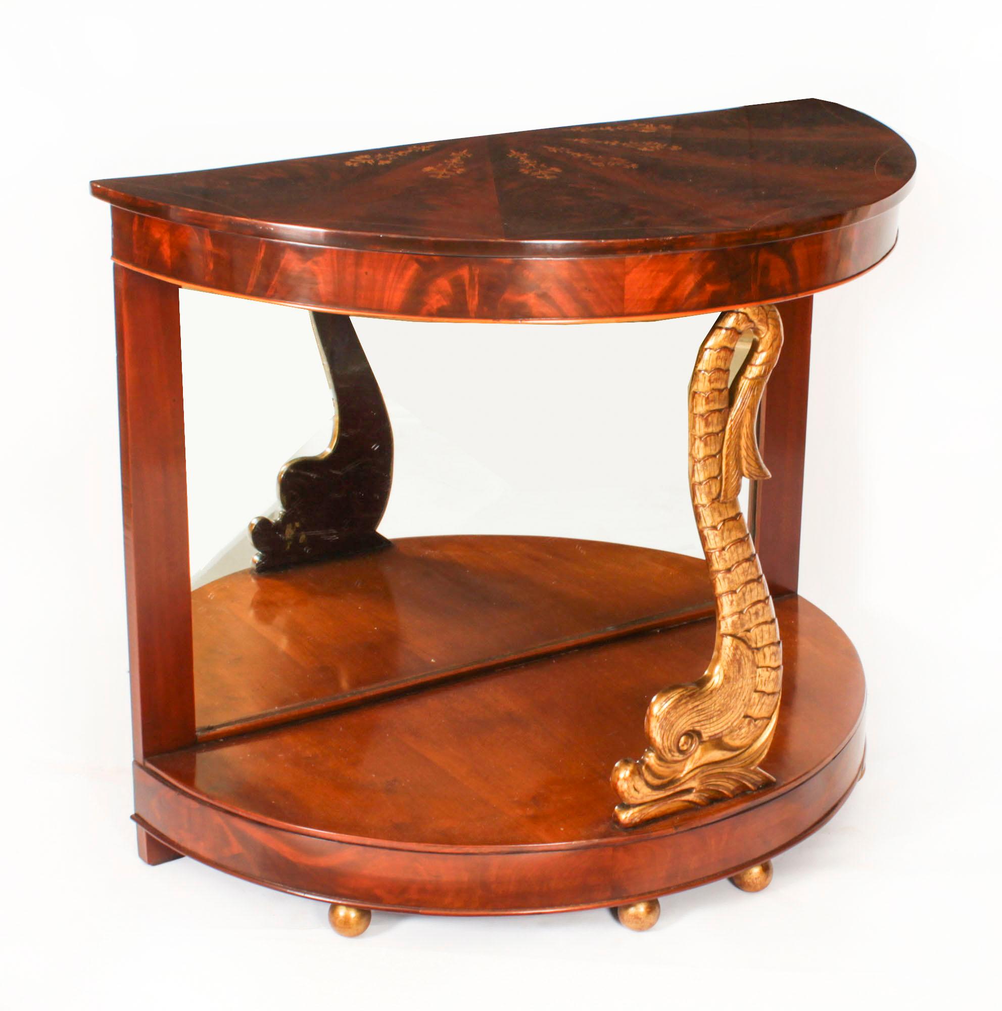 A superb pair of Italian demi lune gilded dolphin console tables, Circa 1870 in date.  

The console tops having stunning starburst flame mahogany and marquetry inlaid tops with line inlaid decoration.

They have striking gilded Dolphin central