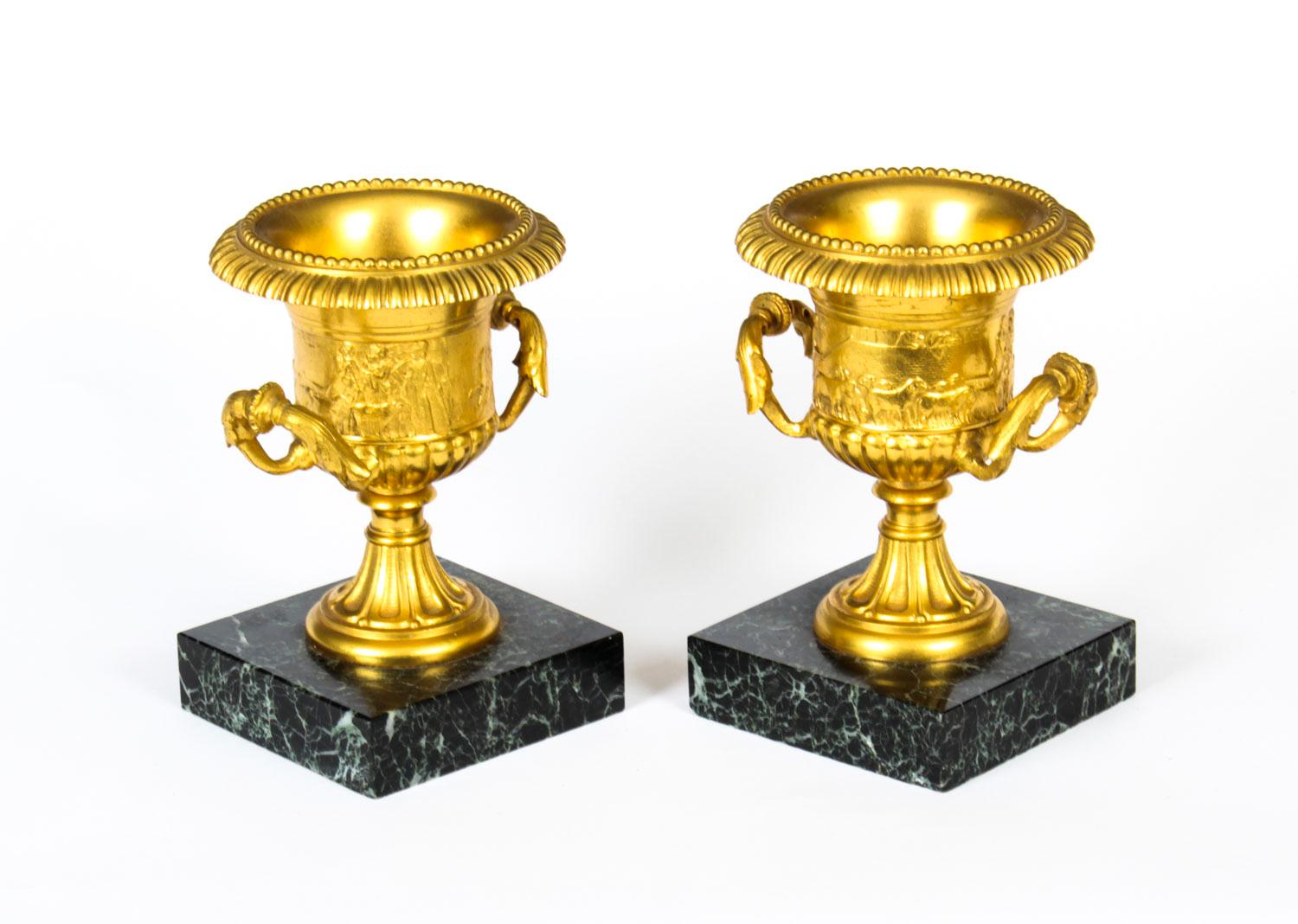 This is a remarkable pair of antique gilt bronze ormolu Italian Grand Tour classical urns, circa 1860 in date.
 
These stunning urns have been superbly cast and have scenes depicting a man rowing his boat with a dog, a farmer with a herd of goats