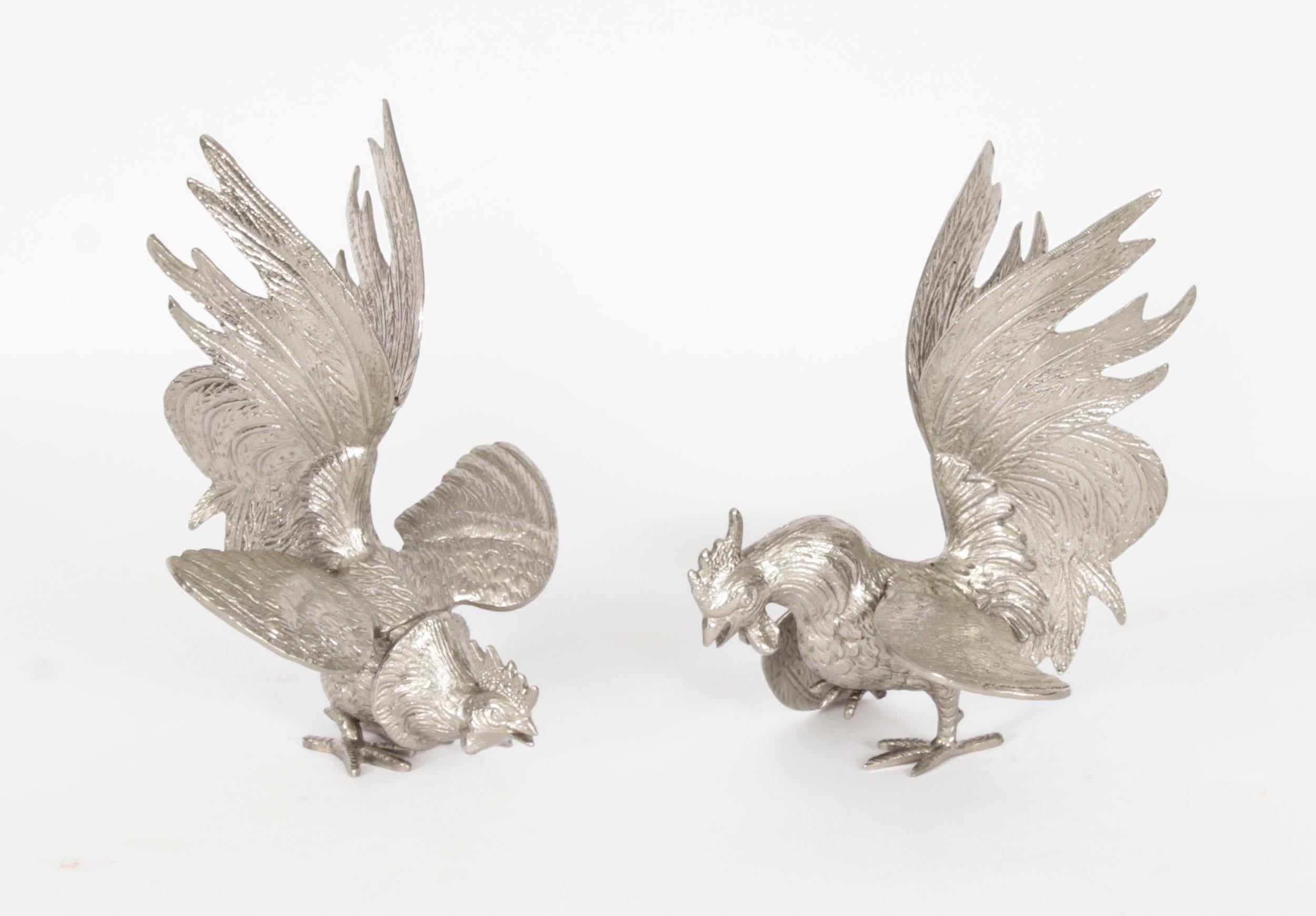 This is a very attractive antique pair of Italian silver plated fighting cockerels, circa 1920 in date.

These beautifully sculpted and hand-chased fine textured cockerels are in realistic aggressive and dynamic fighting poses with flowing plumage