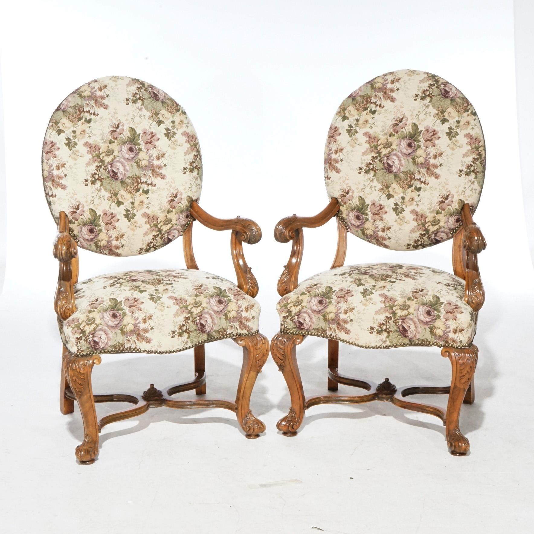 An antique pair of Italian armchairs offer walnut frames with upholstered seat and back, foliate carved scroll form arms, raised on cabriole legs terminating in scroll feet with stylized x-stretcher, circa 1920

Measures - 46.5