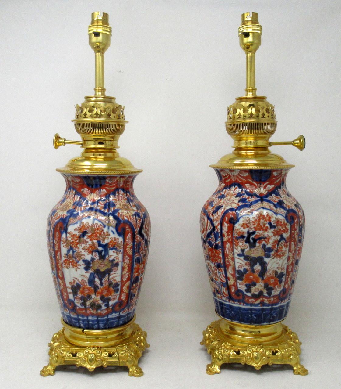 Stunning pair traditional Japanese Imari bulbous form porcelain fluid or oil lamps with original old ormolu burners, of generous proportions, now converted to a pair of electric Table Lamps, complete with their original ornate pierced bases on four