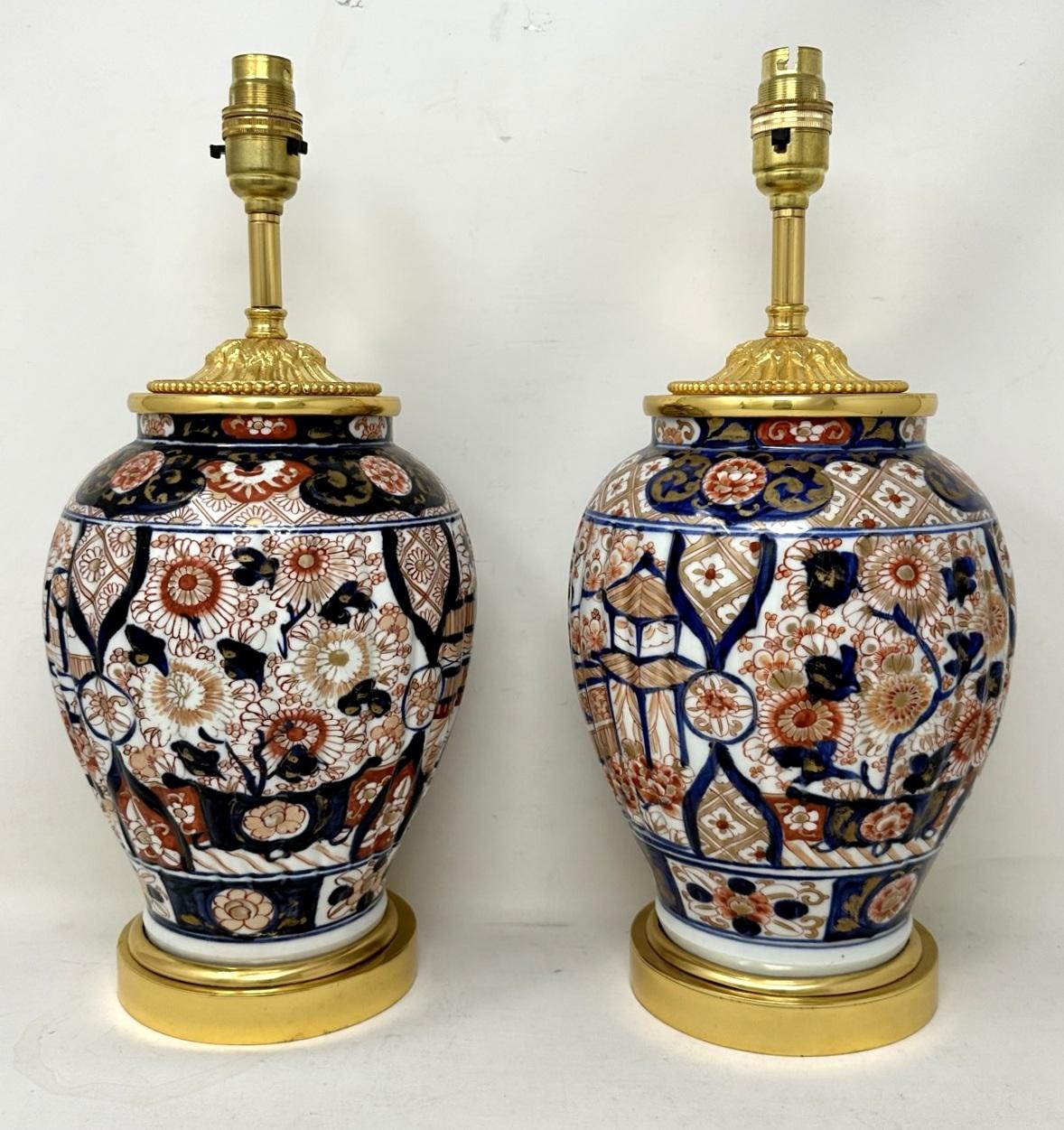 Superbe paire de vases traditionnels japonais en porcelaine de forme bulbeuse imari, de proportions moyennes à grandes, maintenant convertis en une paire de lampes de table électriques, complètes avec des bases circulaires à gradins en bronze doré