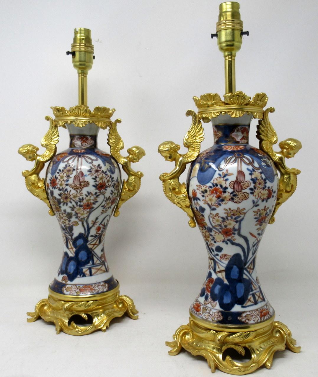 Paire de vases traditionnels japonais en porcelaine Imari de forme bulbeuse et cintrée aux proportions généreuses, maintenant convertis en une paire de lampes de table électriques, chacune avec des montures jumelles en bronze doré représentant des